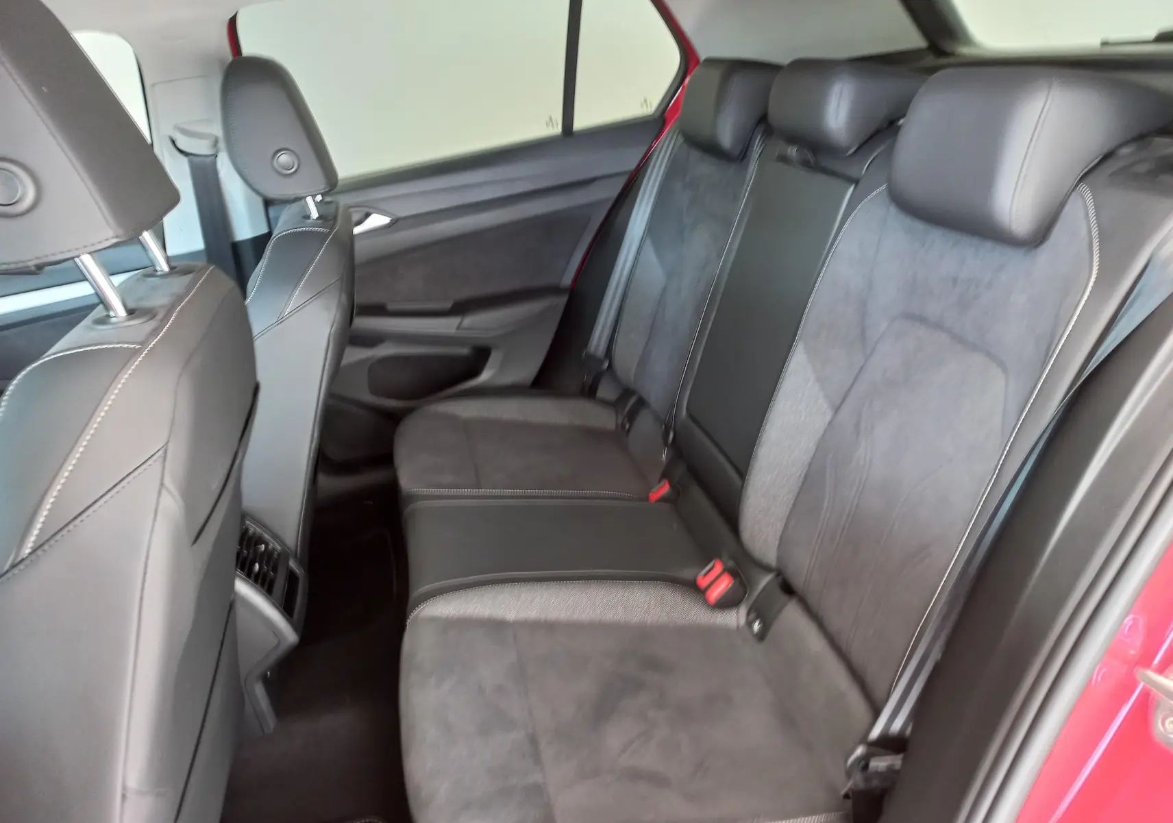 Vue intérieure côté droit des sièges arrière en tissu et cuir noir de la Volkswagen Golf 2.0 TDI 150 DSG7 Rouge Roi 2024.