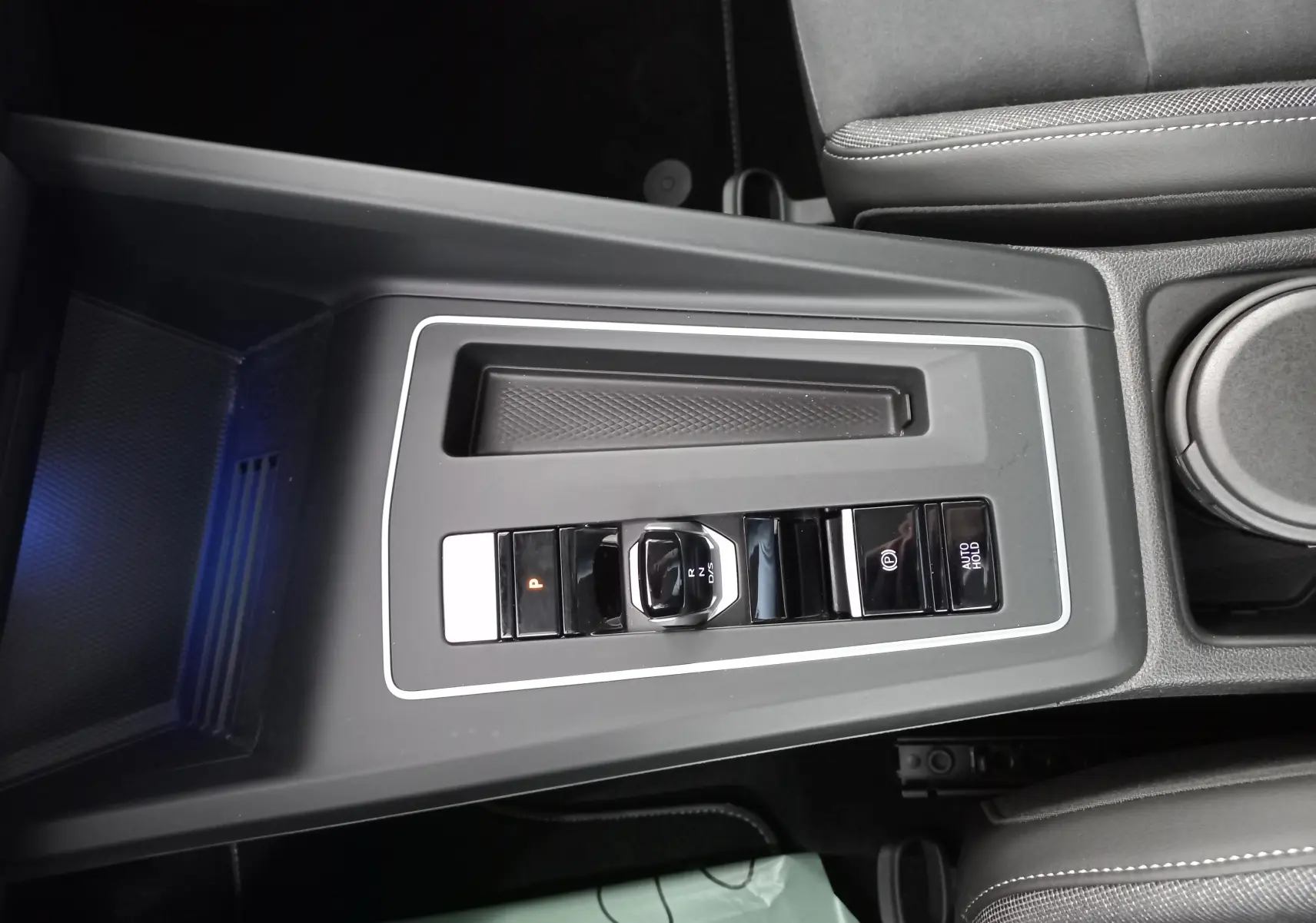 Vue rapprochée de la console centrale noire de la Volkswagen Golf 2.0 TDI 150 DSG7 Style avec levier de vitesse électronique.