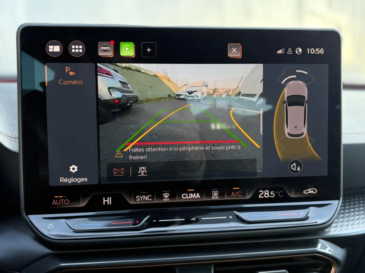 Écran tactile HD 12,9'' montrant la caméra de recul et l'aide au stationnement dans l'habitacle d'une CUPRA Leon blanche.