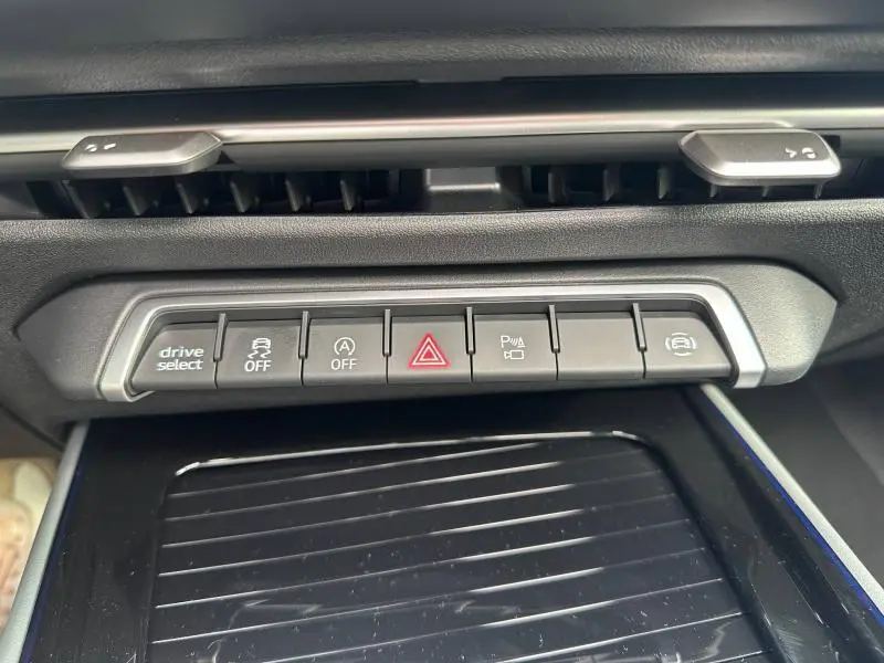 Gros plan sur la rangée de boutons de commande du tableau de bord de l'Audi Q3 gris 2026, version S line.