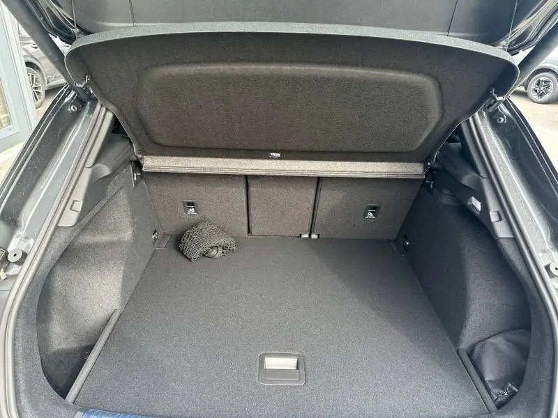Coffre ouvert vu de l'arrière d'un Audi Q3 gris 2026, avec filet de rangement et intérieur spacieux.
