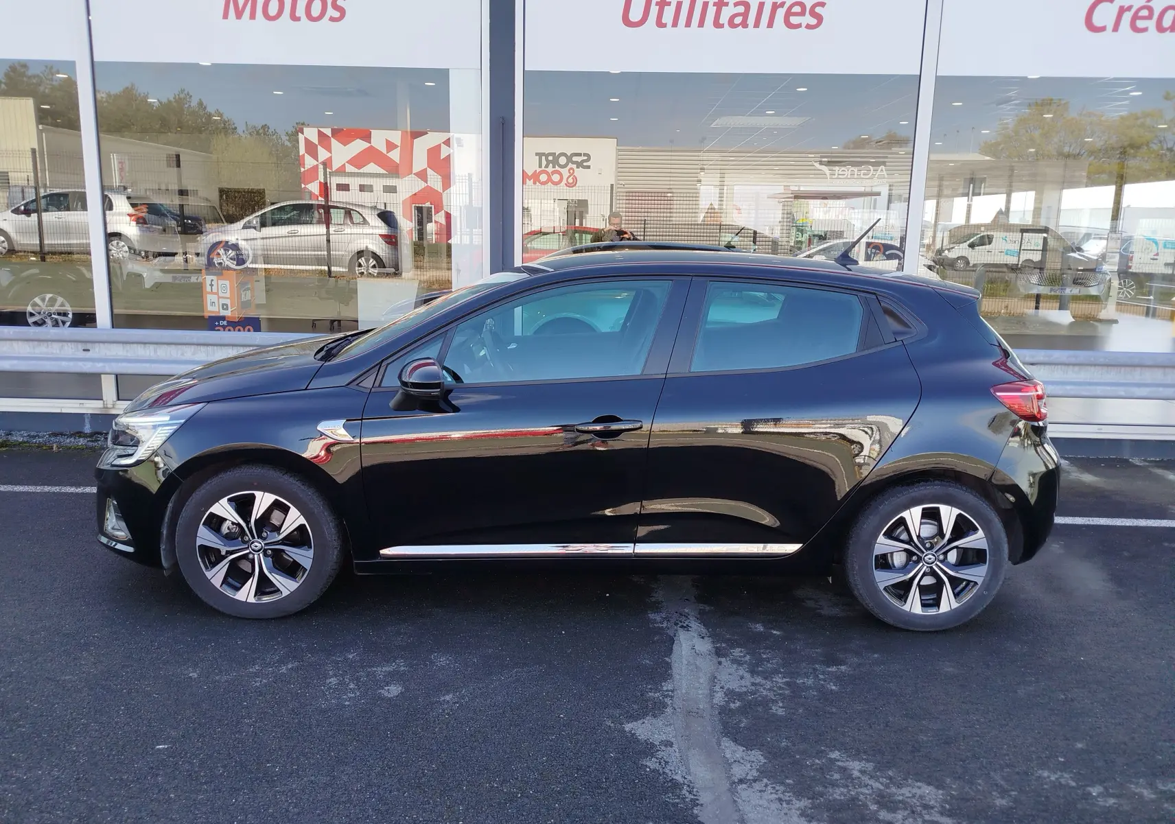 Profil droit d'une Renault Clio 1.6 E-Tech 140ch Limited 2022 noire étoile, avec jantes alliage et détails chromés sur les bas de porte.