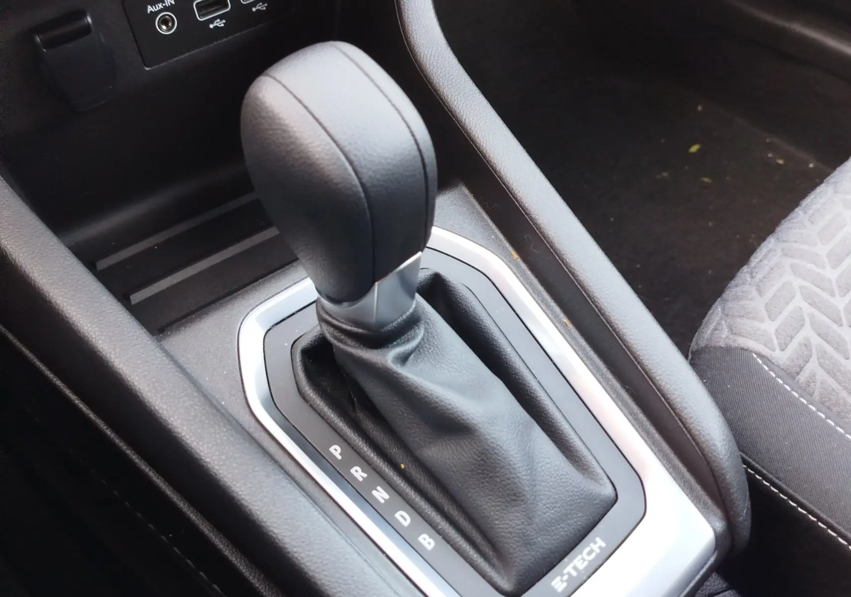 Gros plan sur le levier de vitesses automatique noir de la Renault Clio 1.6 E-Tech 140ch, entouré d’un cadre argenté avec marquages P R N D B.