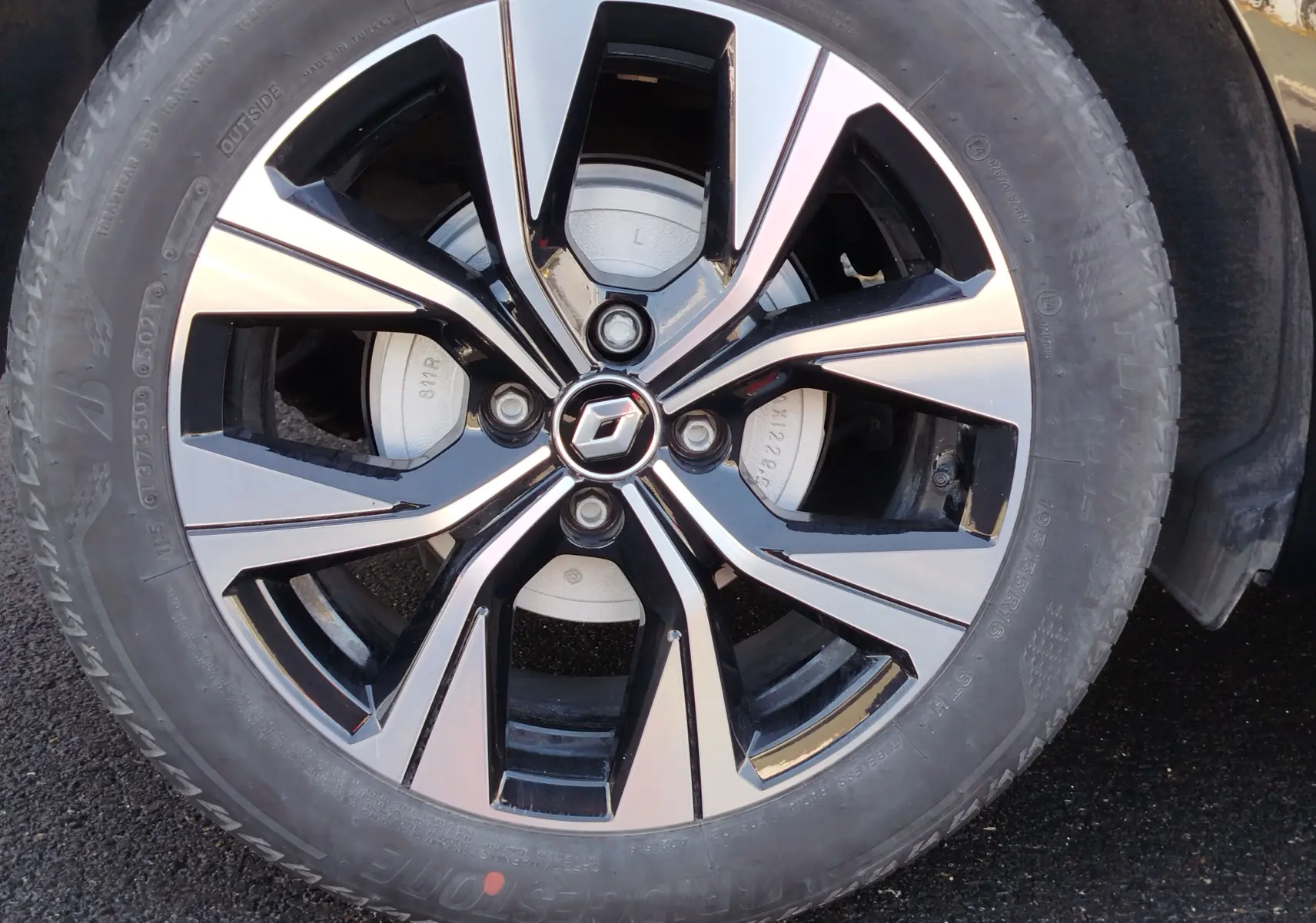 Gros plan sur la jante alliage bicolore noire et argentée de la Renault Clio 1.6 E-Tech 140ch Limited 2022 noire Etoile.