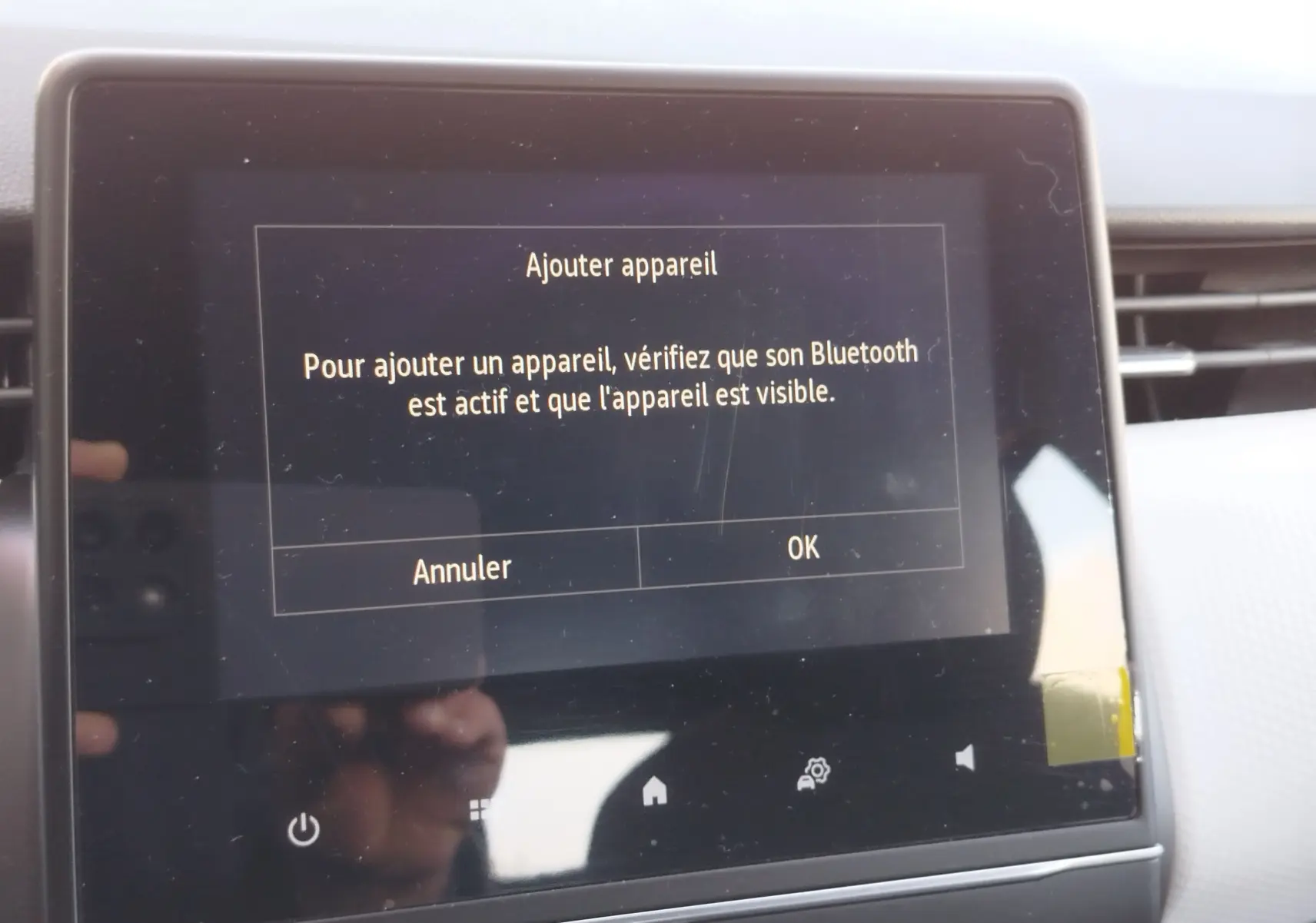 Écran tactile central de la Renault Clio 1.6 E-Tech 140ch Limited 2022 affichant un message d'ajout d'appareil Bluetooth.
