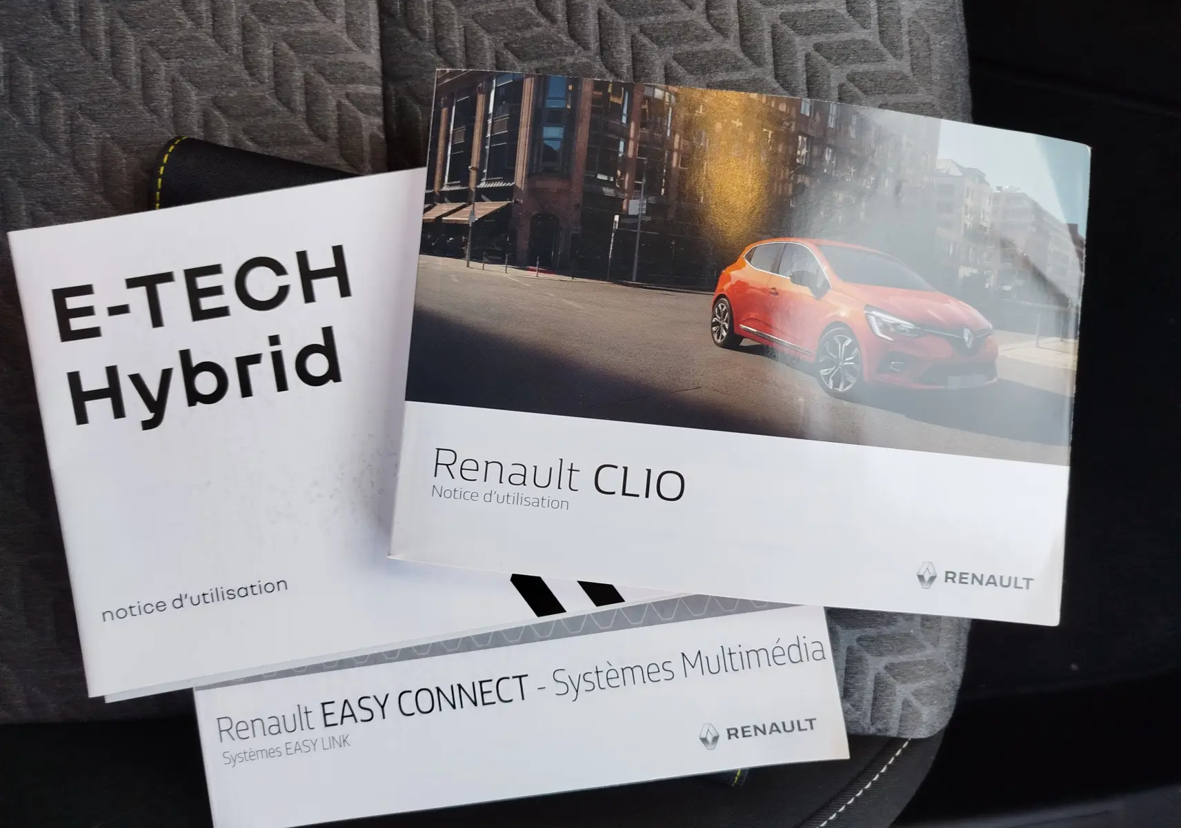 Notice Renault Clio 2022 noir étoile vue de profil droit sur fond urbain, mettant en valeur ses lignes modernes.