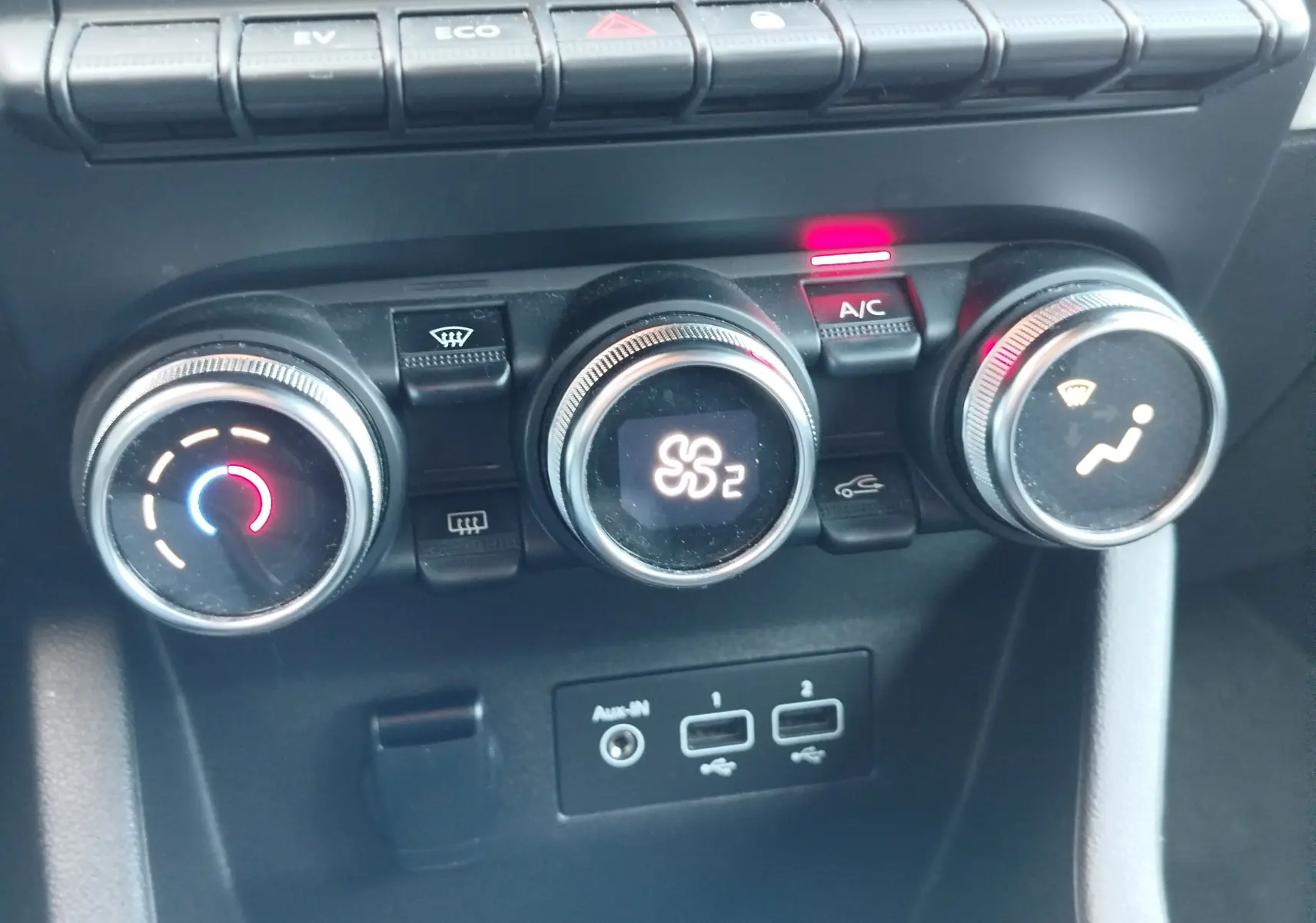 Gros plan sur les commandes de climatisation de la Renault Clio 1.6 E-Tech 140ch Limited 2022, avec réglages lumineux et ports USB.