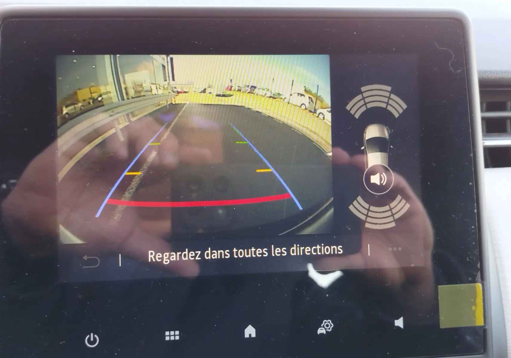 Écran de caméra de recul affichant l’arrière d’une Renault Clio noire Étoile avec lignes de guidage colorées.