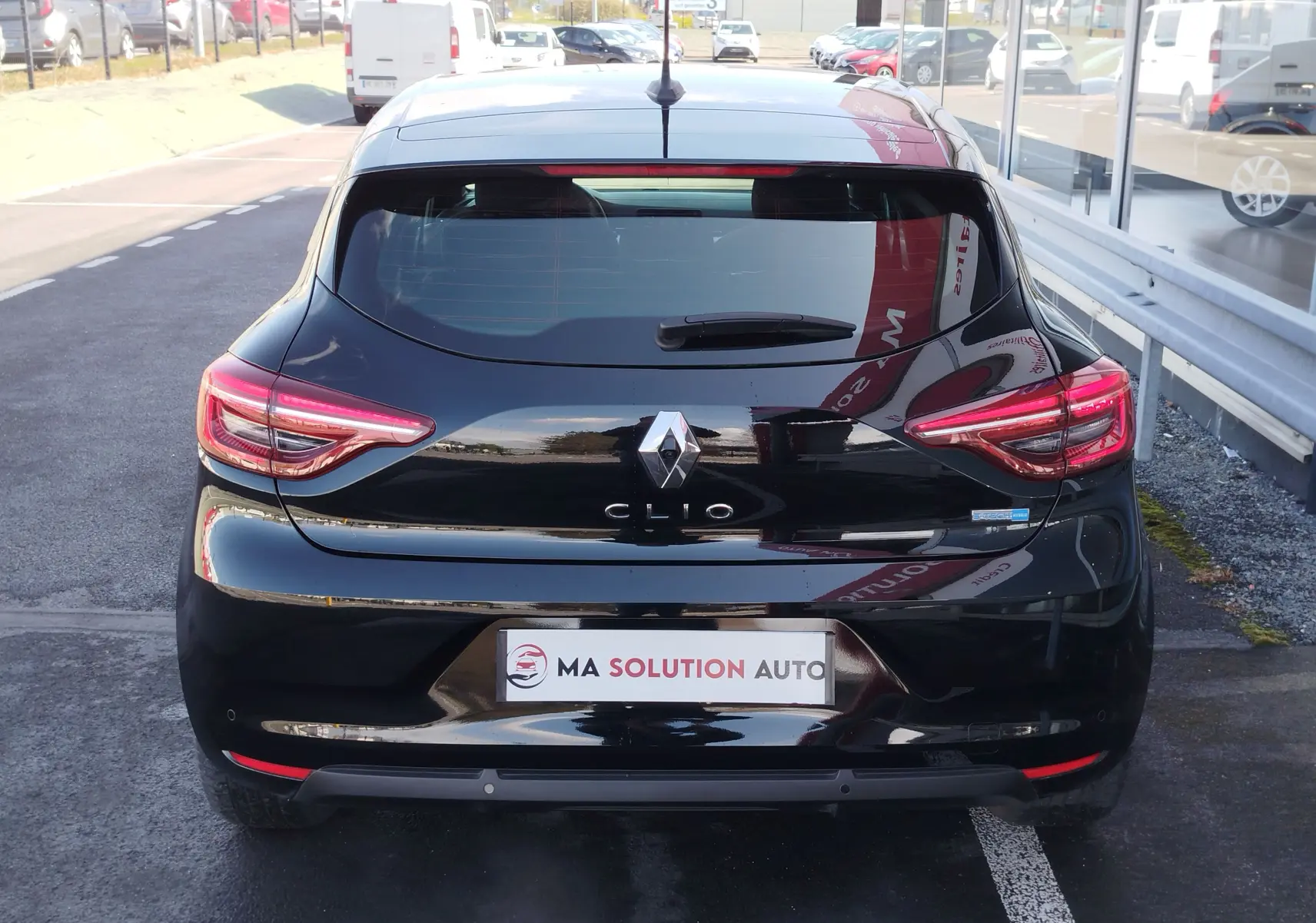 Vue arrière d'une Renault Clio 1.6 E-Tech noir étoile, avec feux LED et logo Renault bien visibles.