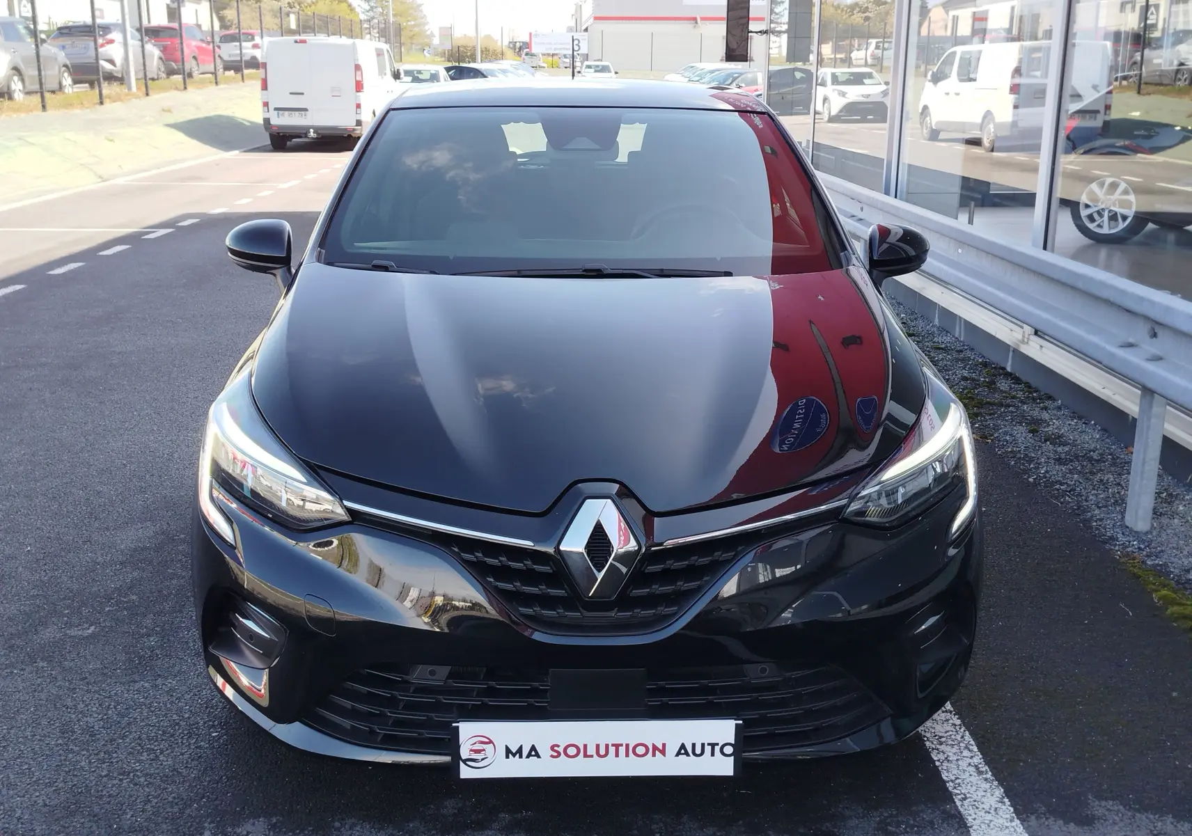 Vue avant d'une Renault Clio 1.6 E-Tech 140ch Limited 2022 noire étoile, avec calandre et phares LED distinctifs.