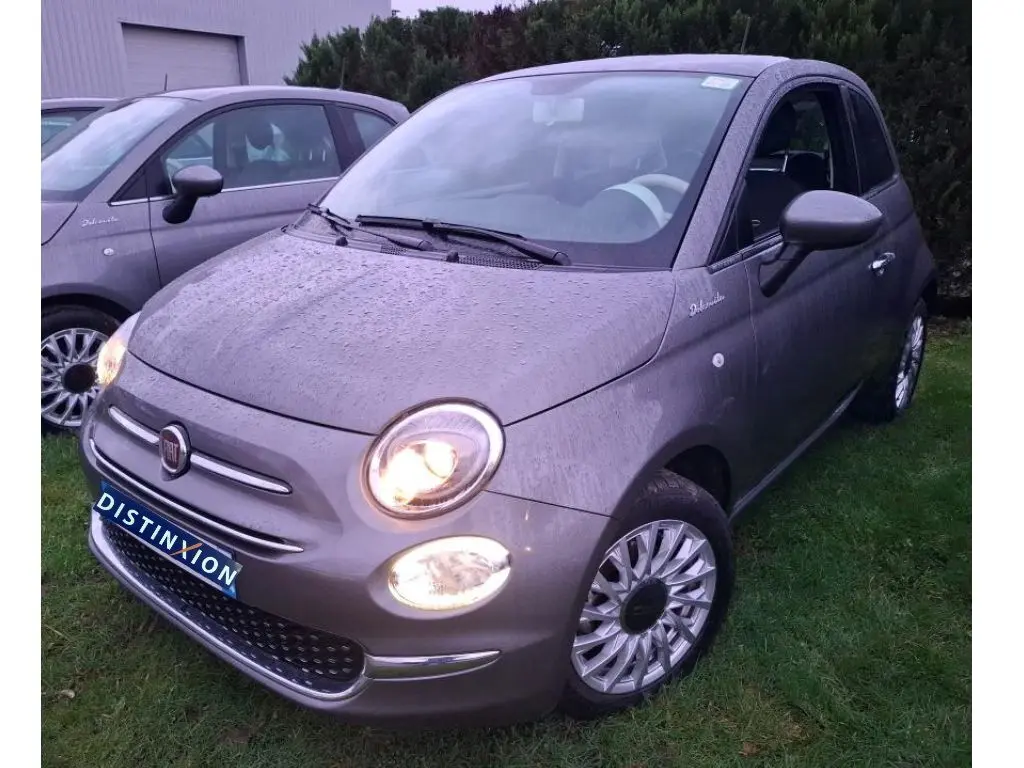 Vue 3/4 avant droite d'une Fiat 500 Gris Electroclash 2022 avec phares allumés et jantes spécifiques Dolcevita.