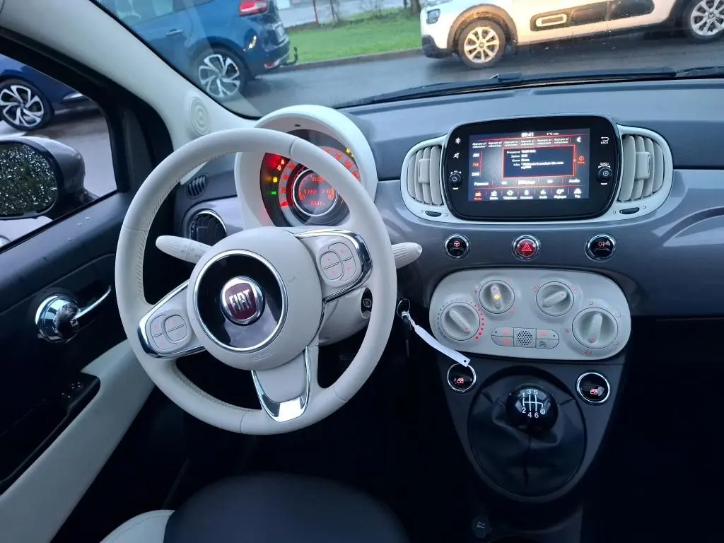 Intérieur de la Fiat 500 2022 Gris Electroclash, vue du poste de conduite avec volant blanc et tableau de bord moderne.