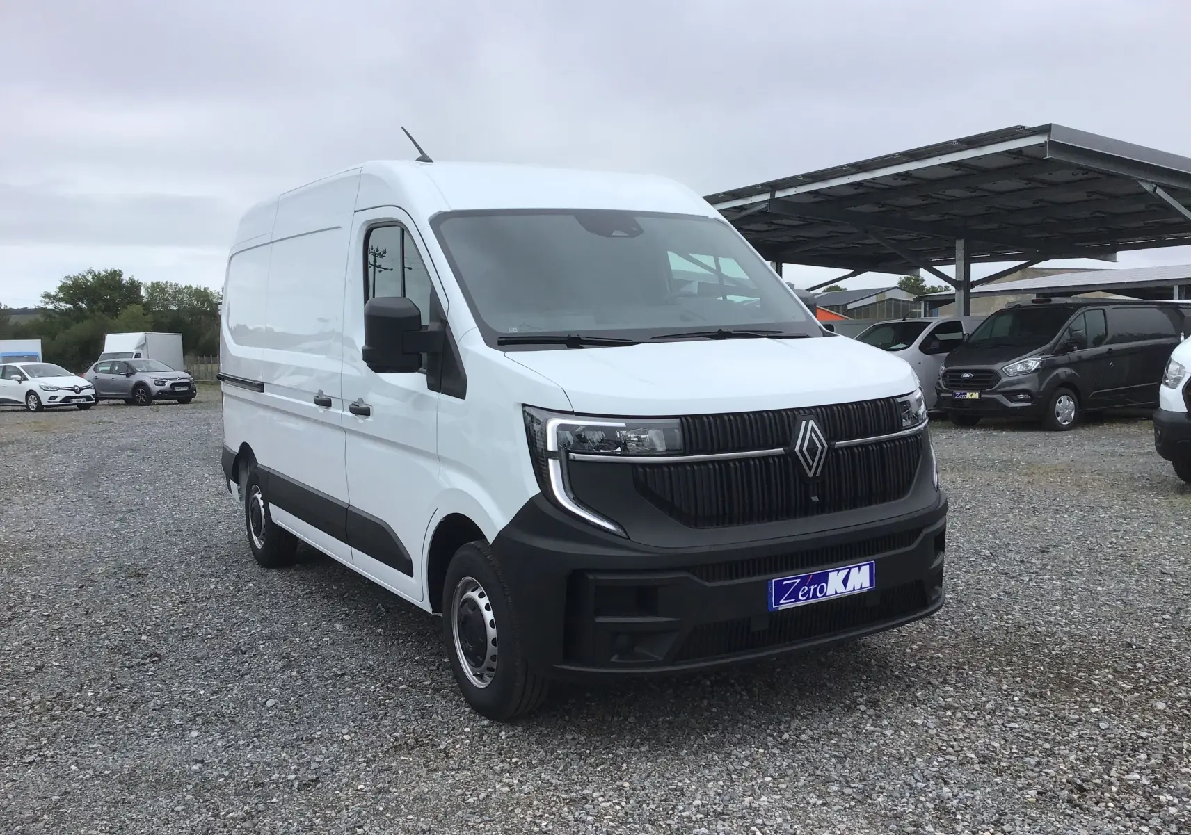 Renault Master blanc vu en 3/4 avant droit, avec calandre noire et plaque d'immatriculation Zero KM visible.