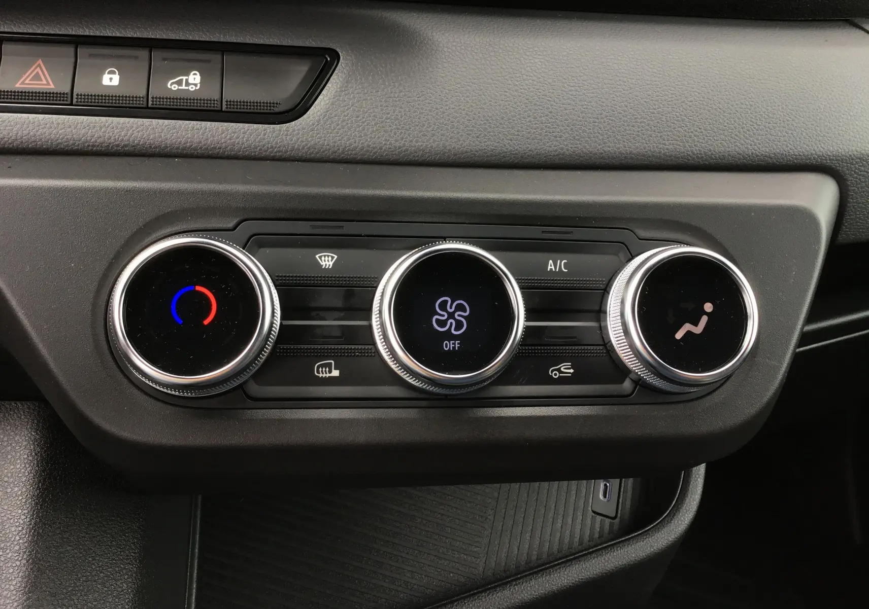 Vue rapprochée des commandes de climatisation du tableau de bord du Renault Master blanc 2025, avec réglages circulaires.