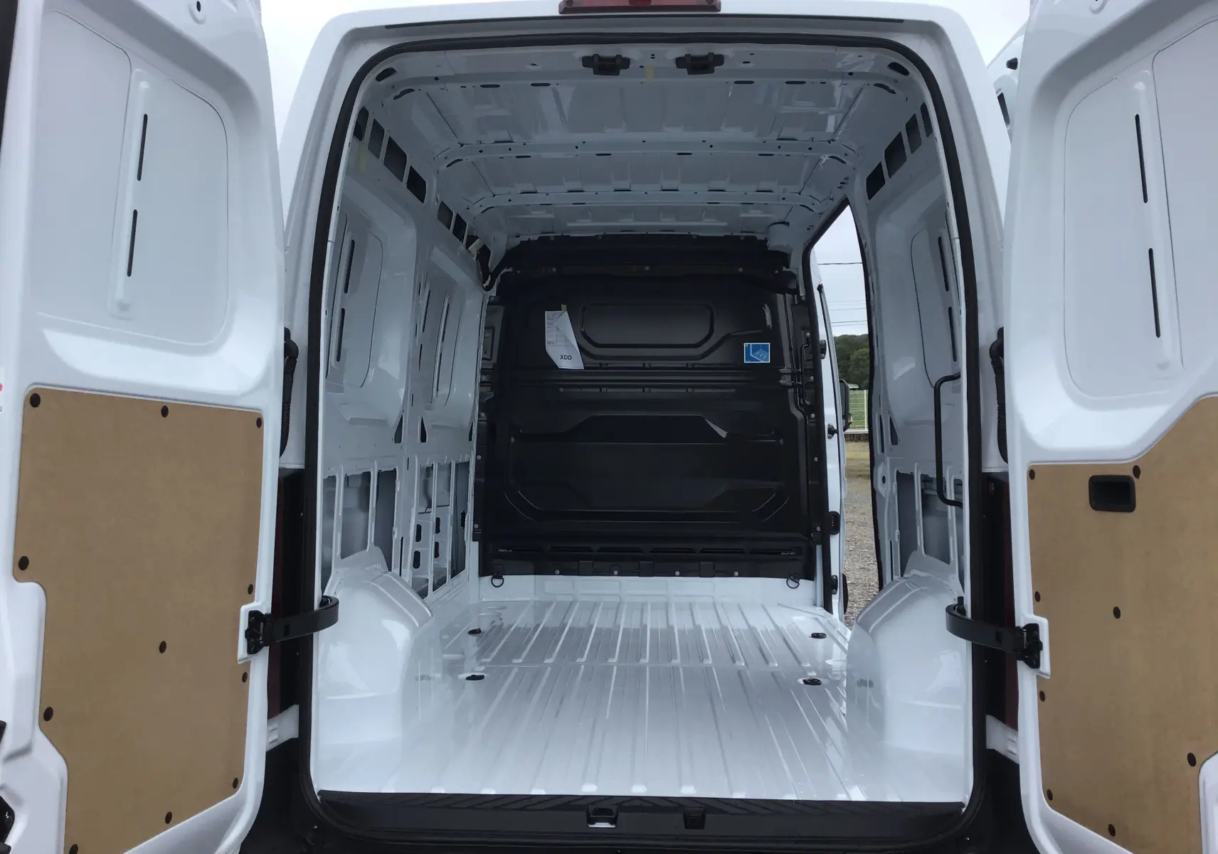 Vue arrière ouverte du Renault Master blanc 2025, montrant la grande zone de chargement vide et les portes battantes ouvertes.