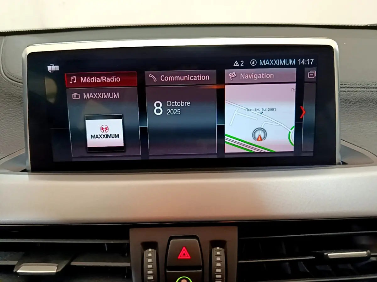 Écran central du tableau de bord du BMW X2 blanc 2023 affichant navigation, communication et média.