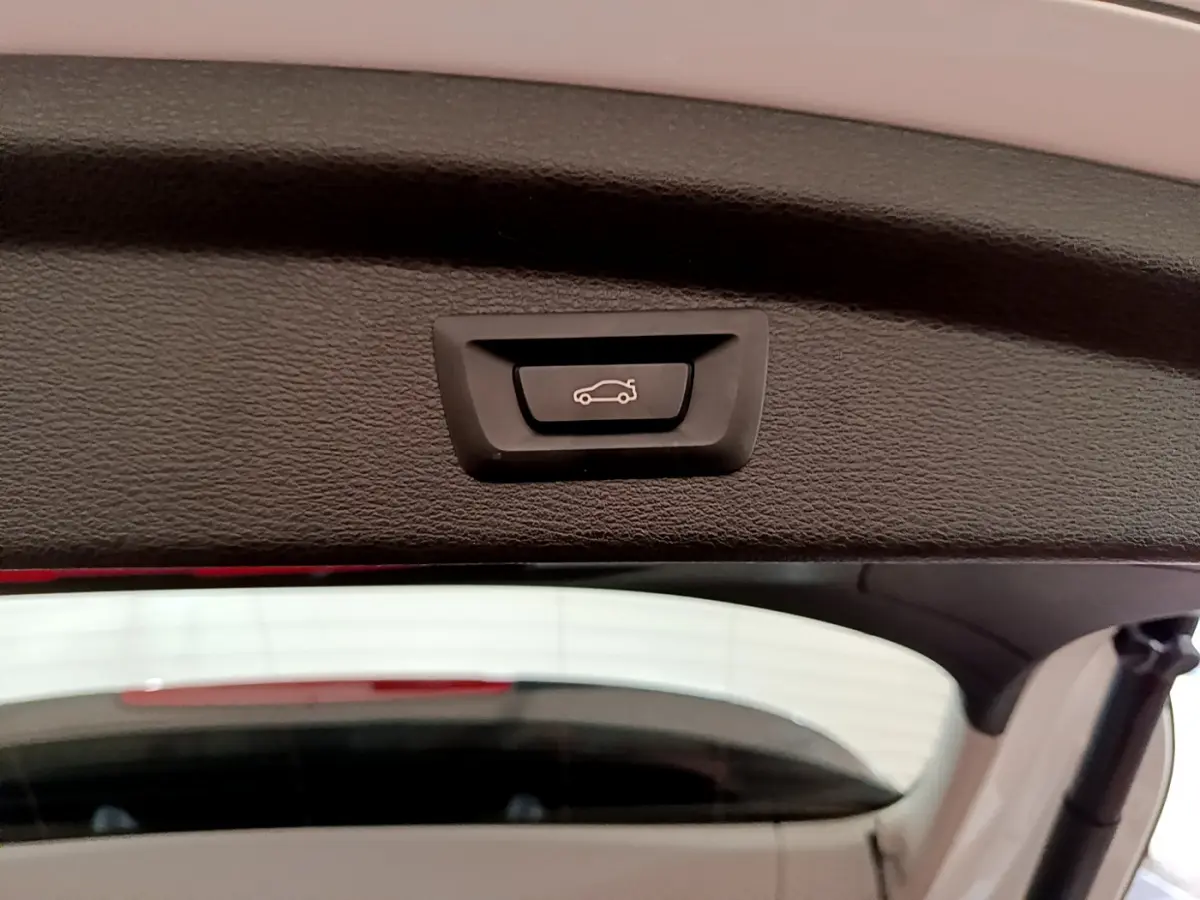 Bouton d'ouverture électrique du coffre sur la partie intérieure du hayon d'un BMW X2 blanc 2023.