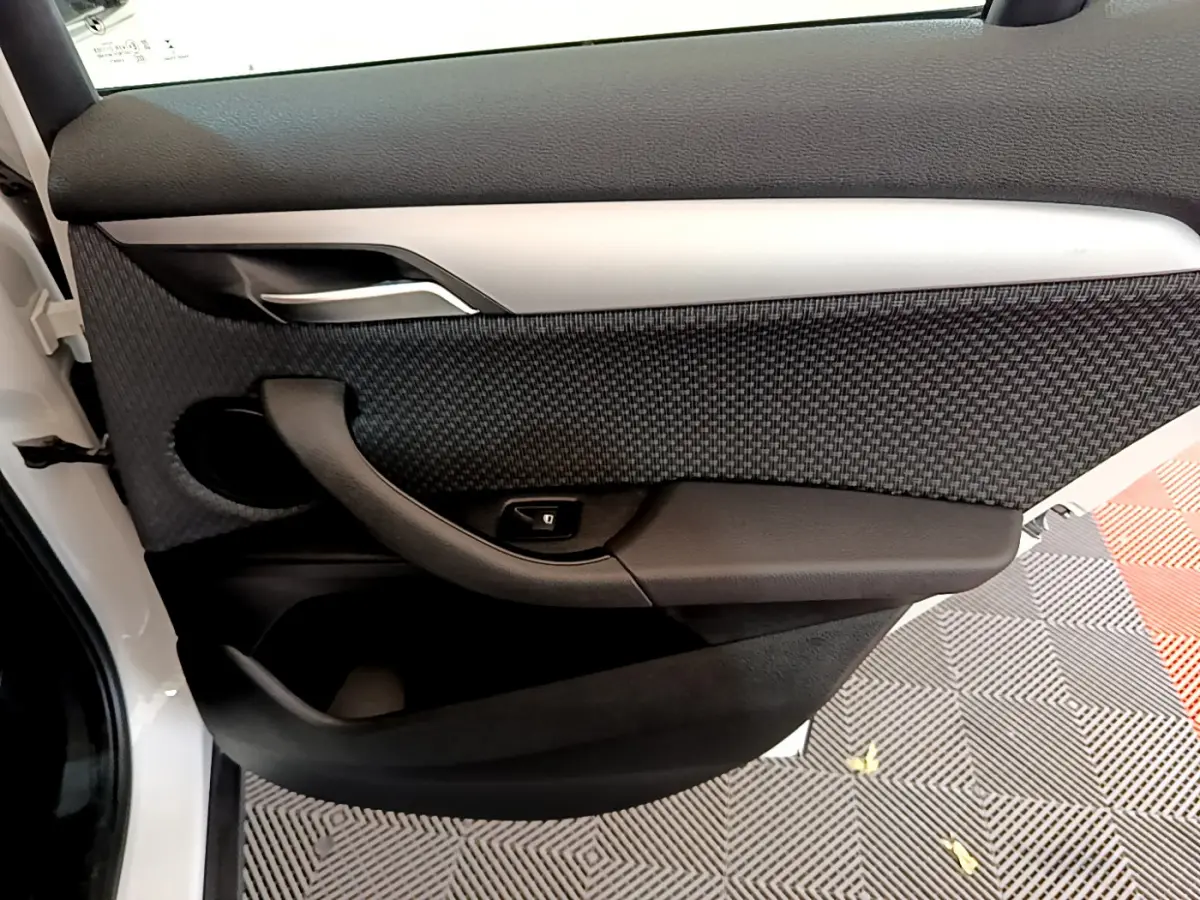 Gros plan sur la porte arrière gauche intérieure noire et tissu texturé du BMW X2 blanc 2023 sDrive18i Business DesignDKG7