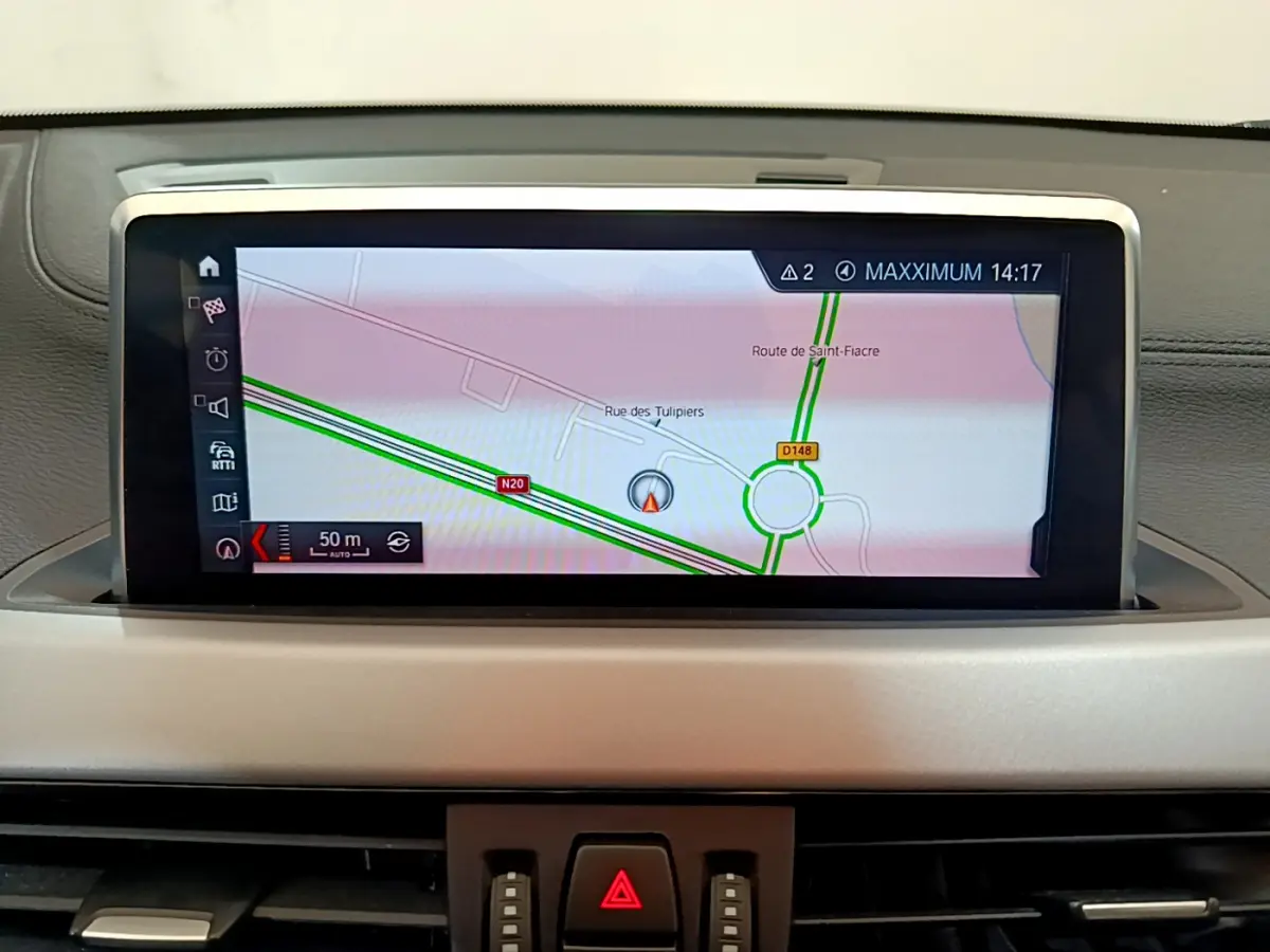 Écran central du système de navigation 3D du BMW X2 blanc, affichant une carte routière détaillée.