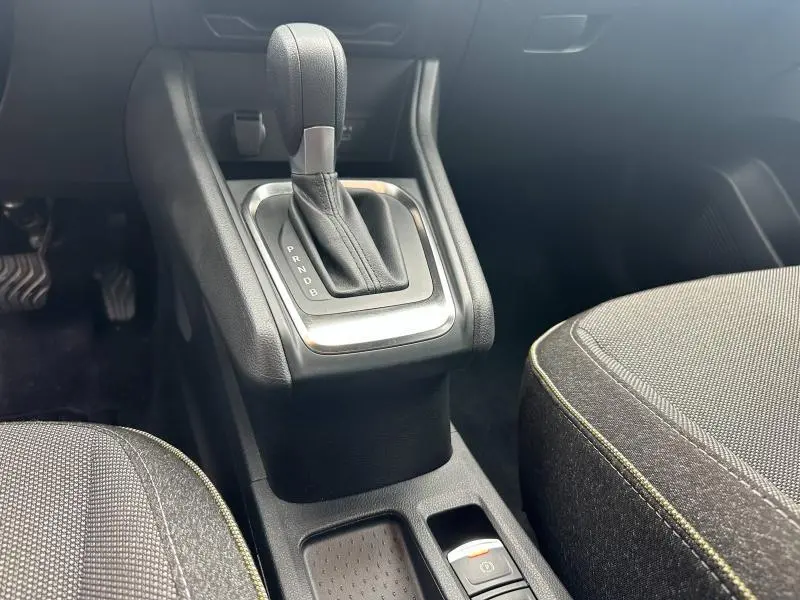 Gros plan sur la console centrale avec levier de boîte automatique et sièges tissu gris du Renault Captur 1.6 E-Tech hybride.