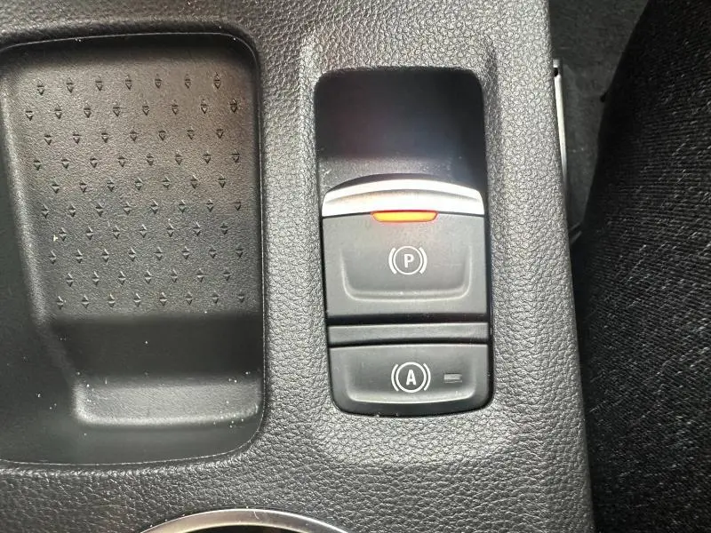 Gros plan sur les commandes de frein à main électrique et arrêt/démarrage auto du Renault Captur 1.6 E-Tech bleu/noir.