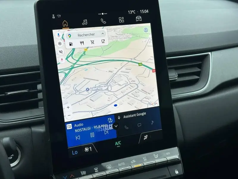 Écran tactile central affichant la navigation GPS et l'assistant Google dans un Renault Captur 2025.