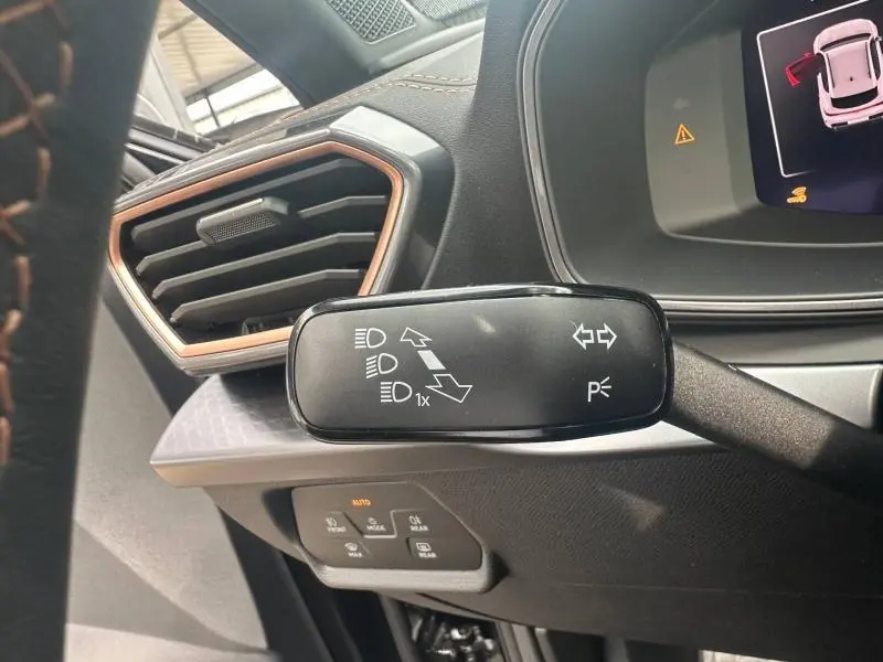 Gros plan sur la commande de clignotants à gauche du tableau de bord du CUPRA Formentor noir Minuit métallisé 2026.