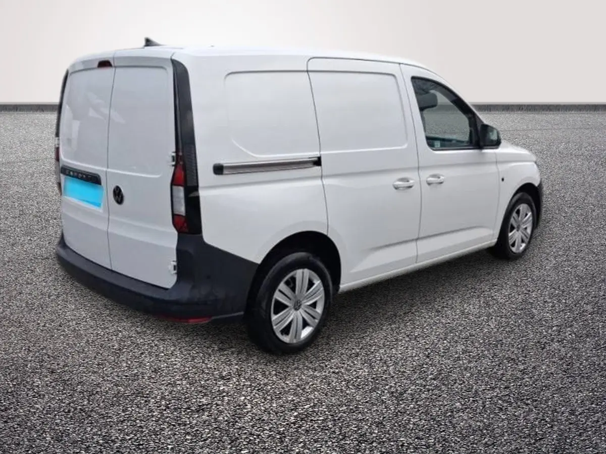 Vue 3/4 arrière droite d'un utilitaire Volkswagen Caddy blanc avec portes latérales coulissantes et hayon fermé.