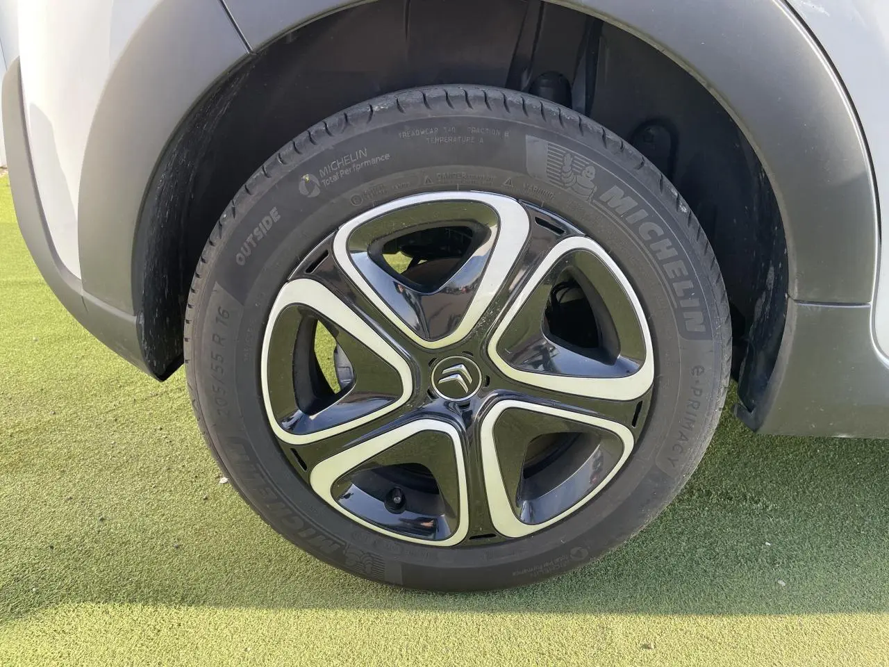 Gros plan sur la roue avant droite de la Citroën C3 blanche avec jante alliage noire et argentée au design moderne.