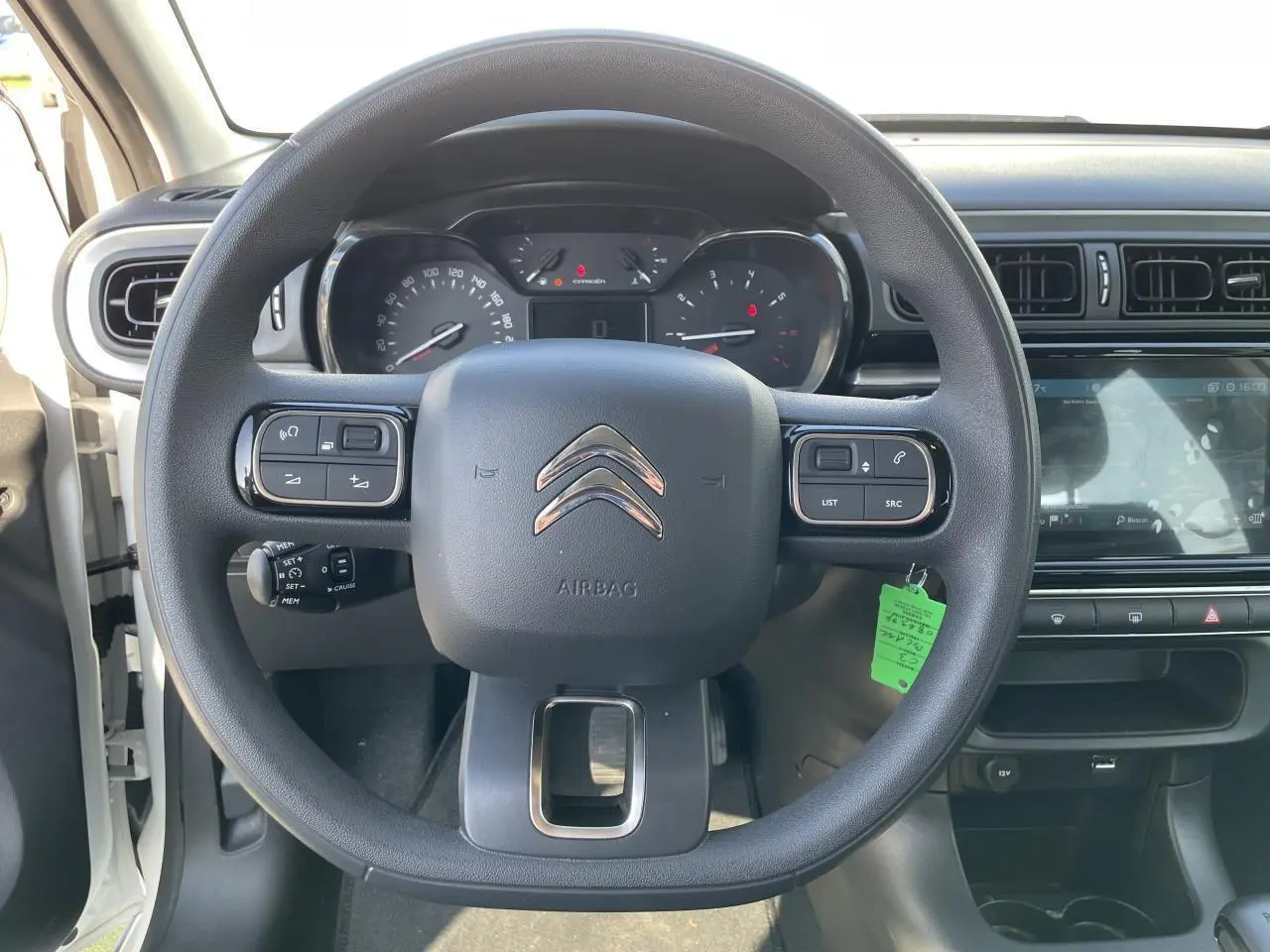 Vue centrée sur le volant noir de la Citroën C3 blanche avec tableau de bord et écran tactile visible à droite.