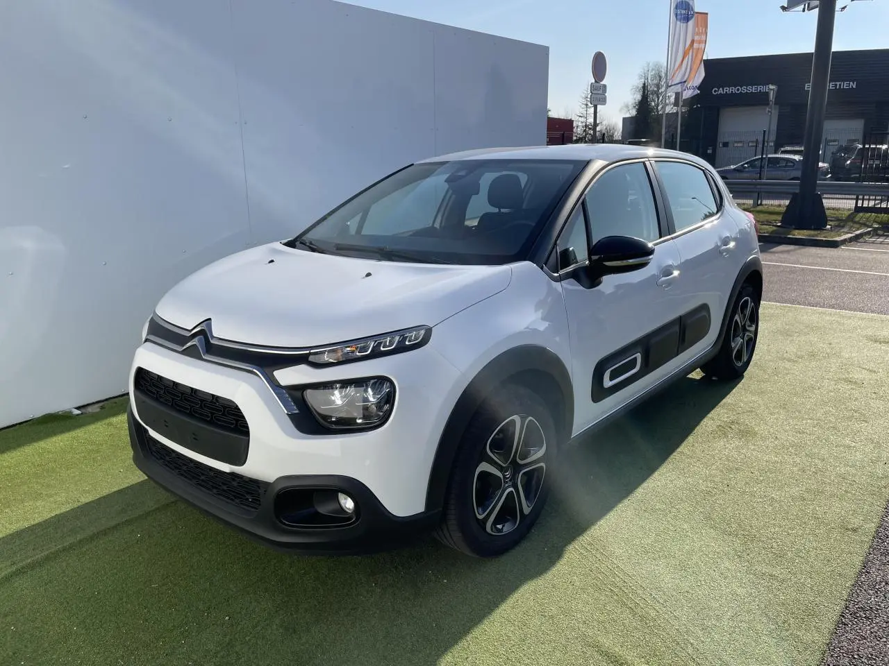 Citroën C3 blanc banquise vue 3/4 avant droit avec protections latérales noires et jantes 16 pouces design.