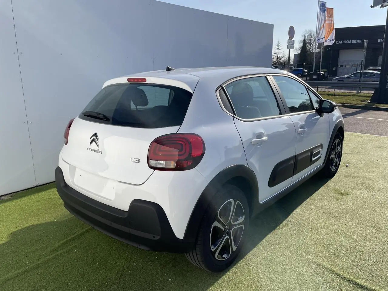 Vue 3/4 arrière droite d'une Citroën C3 blanche Banquise avec protections latérales noires et feux arrière à effet 3D.