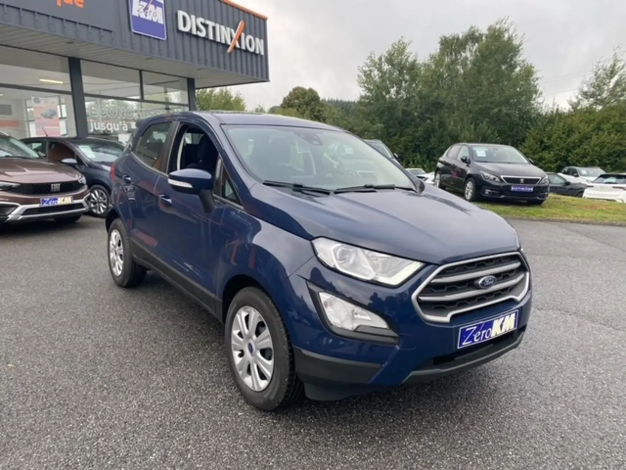 Ford EcoSport bleu Abysse en 3/4 avant droit, avec calandre chromée et feux de jour LED visibles.