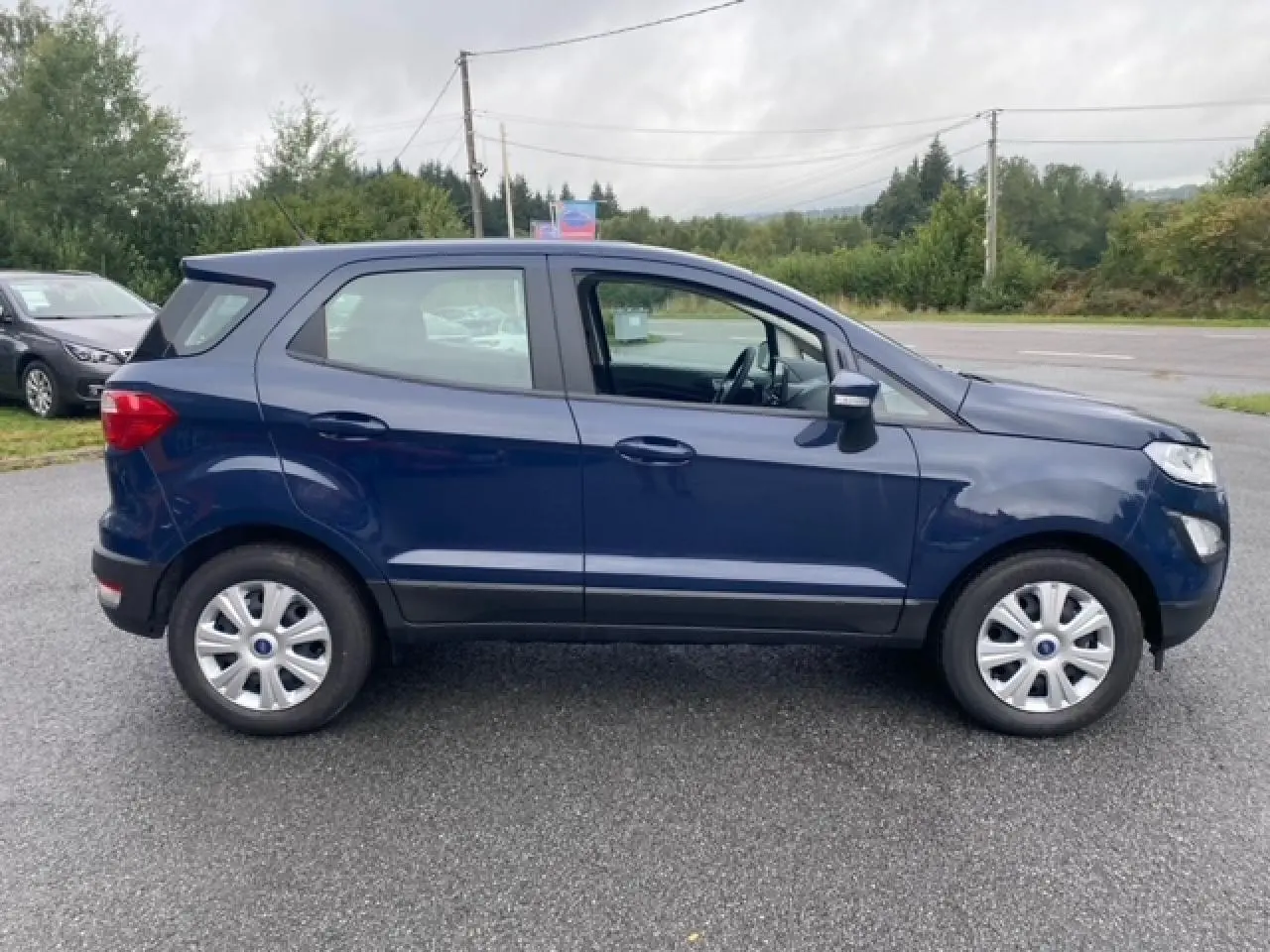 Ford EcoSport bleu abysse vu de profil côté gauche, compact avec jantes acier et rétroviseurs noirs.