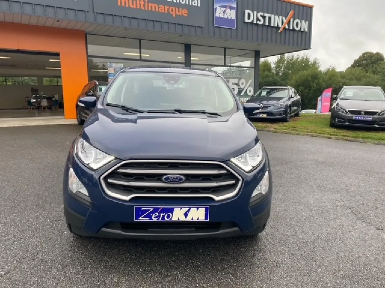 Vue frontale d'un Ford EcoSport bleu abysse 2022 avec calandre chromée et feux de jour LED visibles.