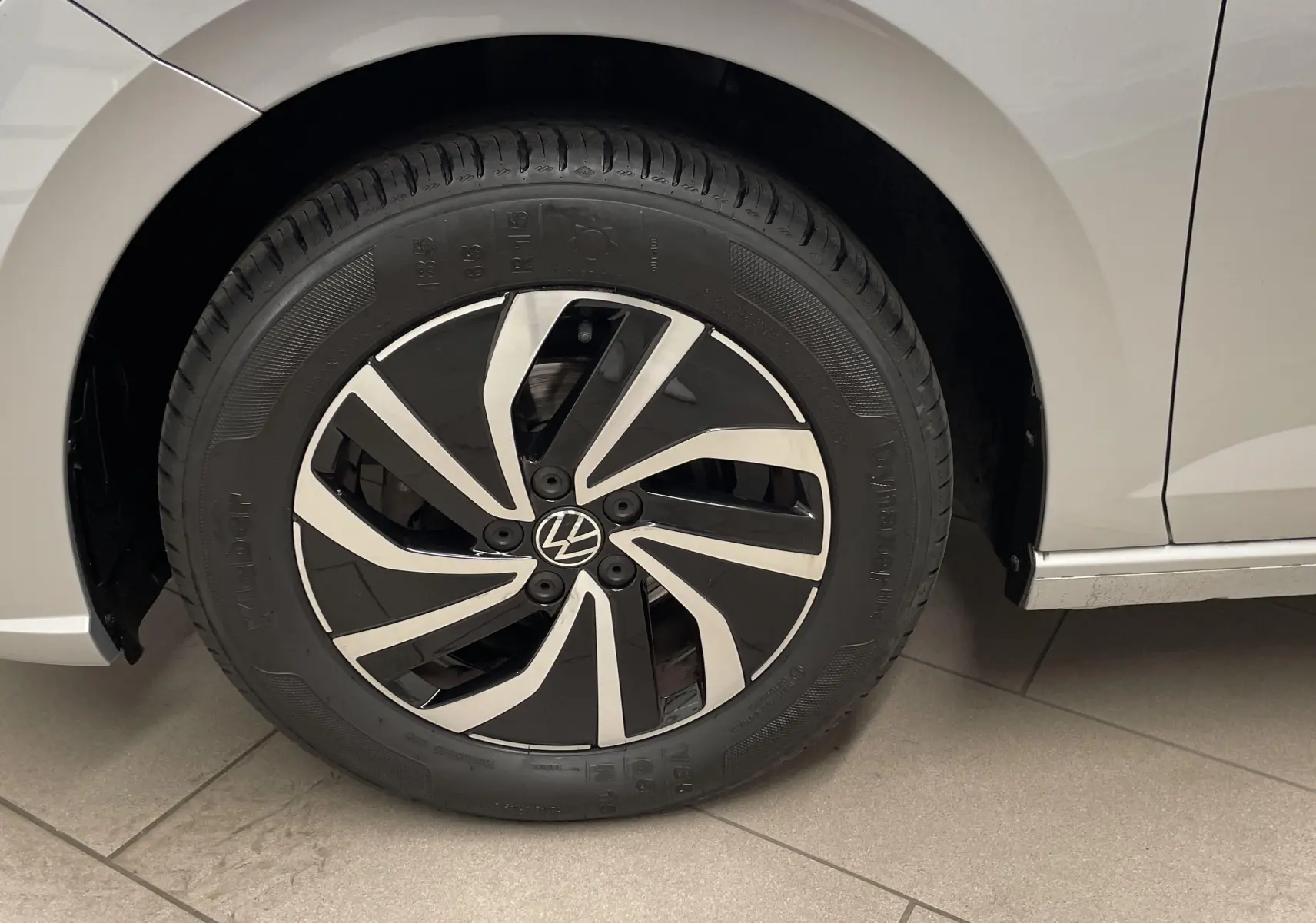 Gros plan sur la roue avant gauche d'une Volkswagen Polo 2023 argent métallisé avec jante noire et argentée.