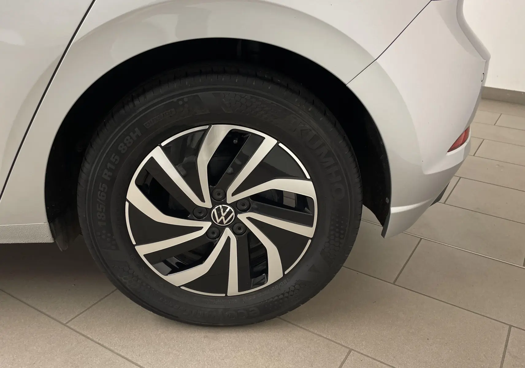 Gros plan sur la roue arrière droite d'une Volkswagen Polo 2023 en reflet d'argent avec jante alliage noire et argentée.