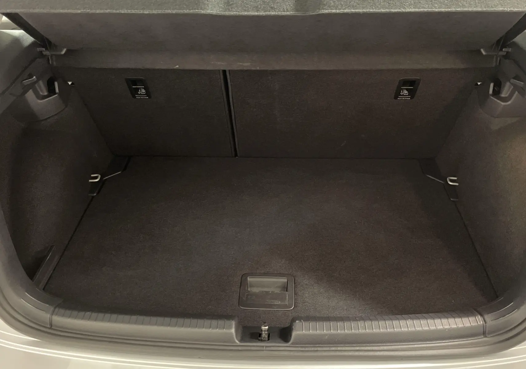 Coffre ouvert d'une Volkswagen Polo 2023 couleur reflet d'argent, montrant l'espace de rangement intérieur.