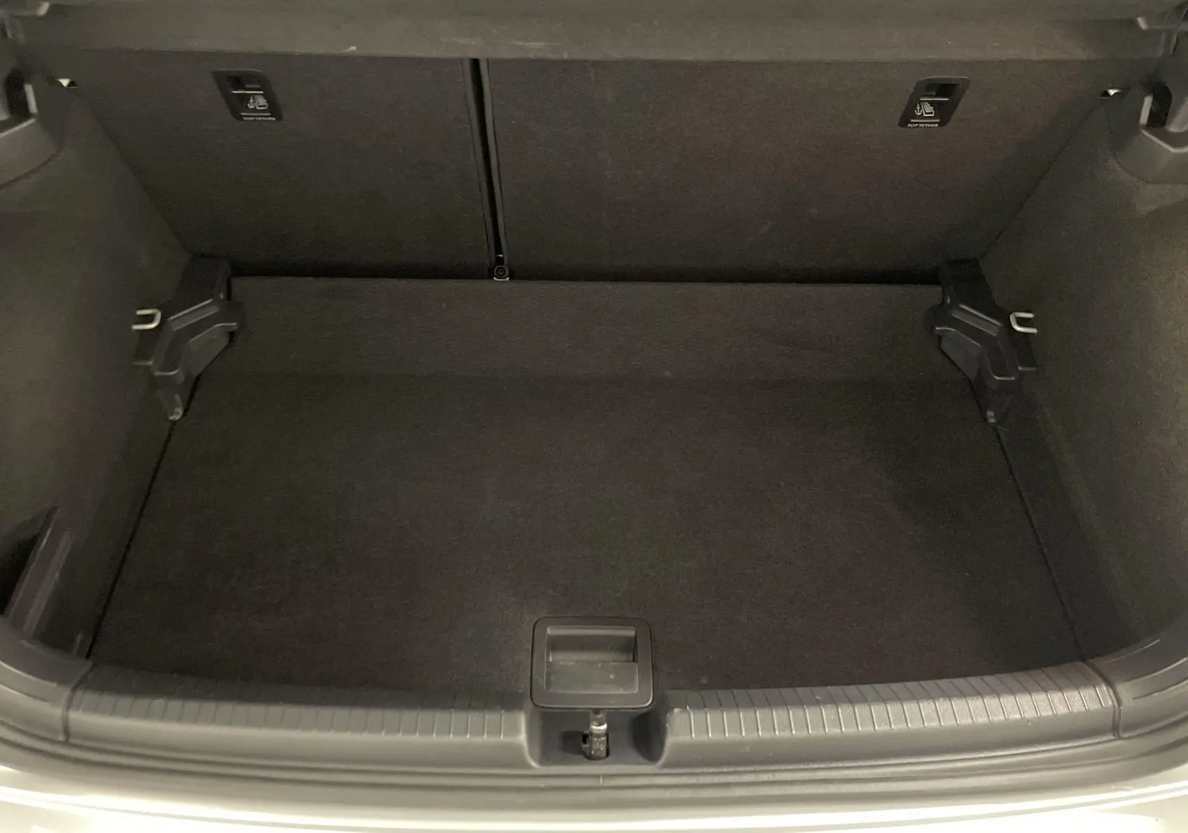 Coffre ouvert vu de dessus d'une Volkswagen Polo 2023 argent métallisé, intérieur noir et espace de rangement vide.