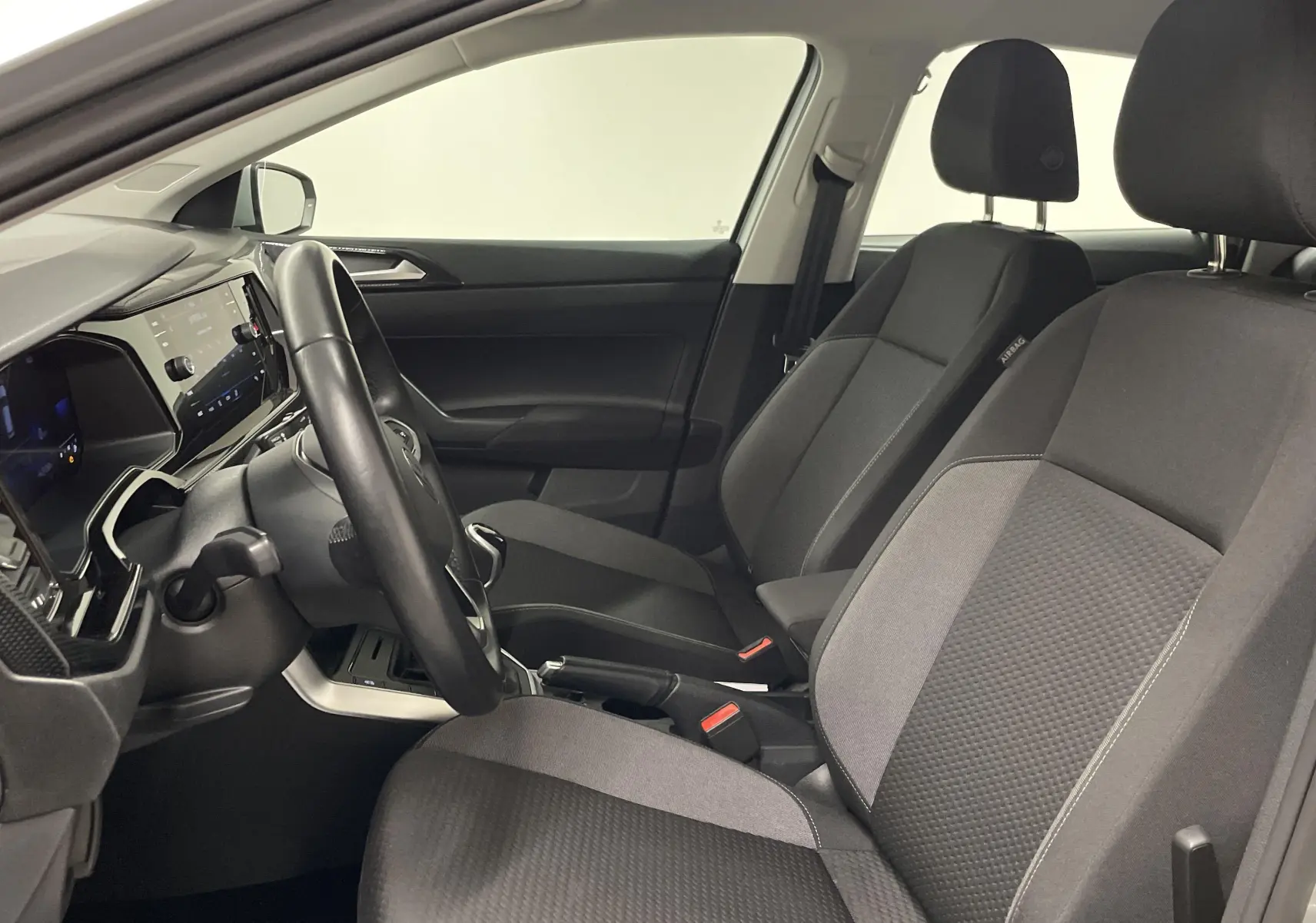 Intérieur de la Volkswagen Polo 2023 en reflet d'argent, vue côté conducteur sur les sièges et le tableau de bord.