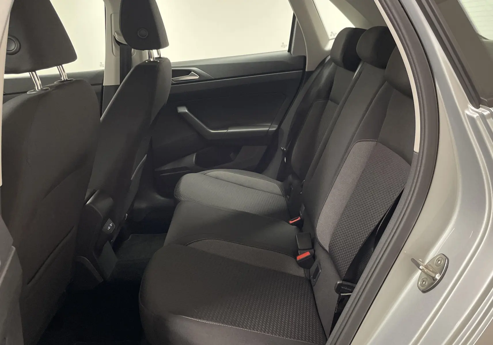Vue intérieure côté droit sur les sièges arrière noirs et gris d'une Volkswagen Polo 2023 couleur reflet d'argent.