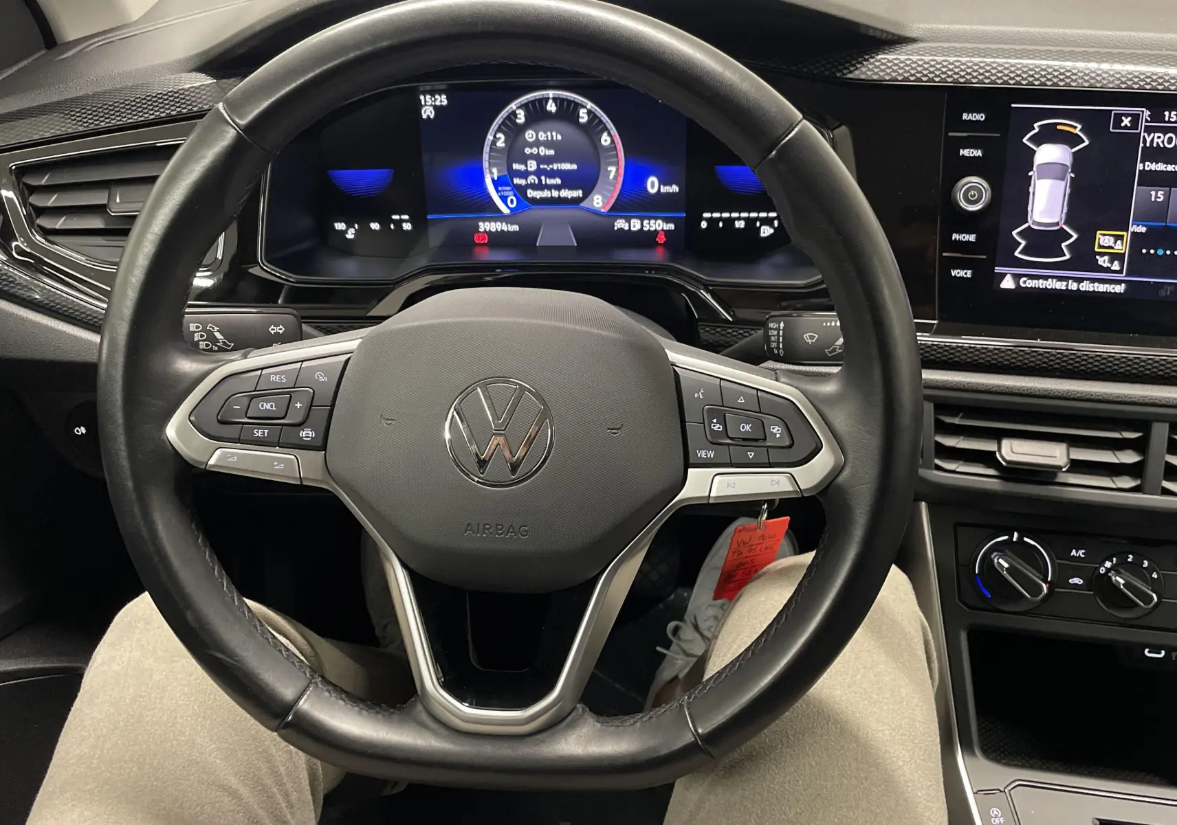 Vue intérieure du tableau de bord et volant noir d'une Volkswagen Polo 2023, avec affichage numérique et commandes au volant.