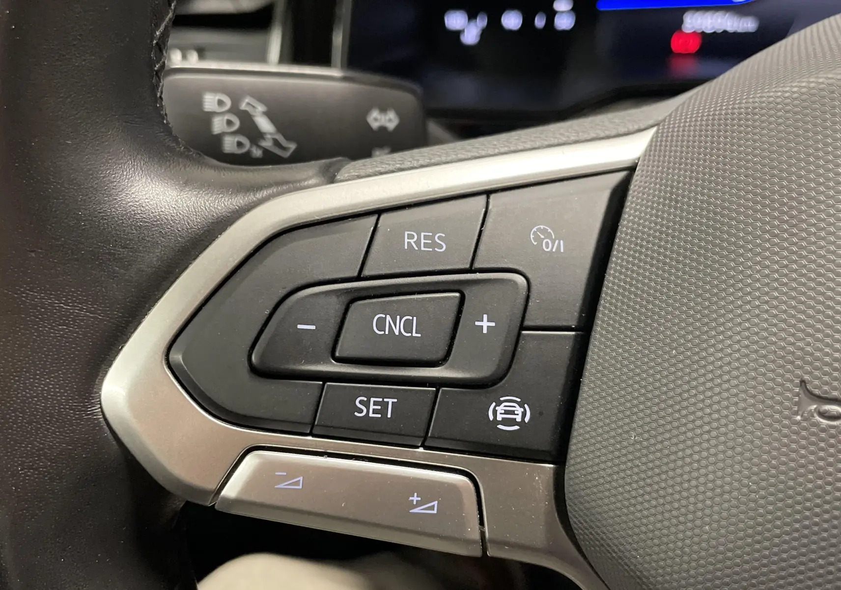 Gros plan sur les commandes de régulateur de vitesse au volant d'une Volkswagen Polo 2023 finition Life.