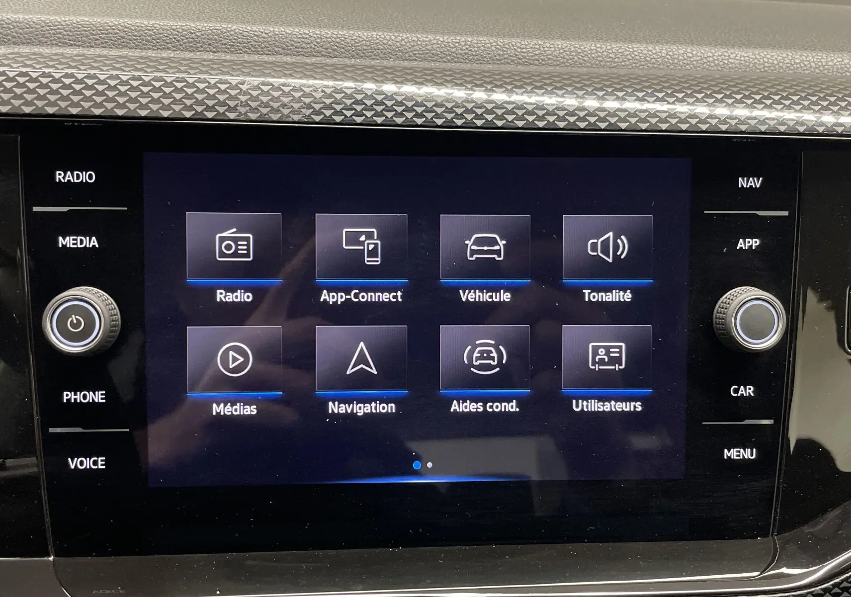 Écran tactile central du tableau de bord de la Volkswagen Polo 2023 affichant les options radio, navigation et aides à la conduite.