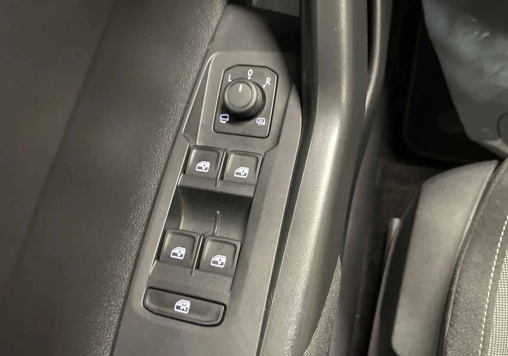 Panneau de commandes des vitres et rétroviseurs côté conducteur dans l'habitacle d'une Volkswagen Polo 2023.