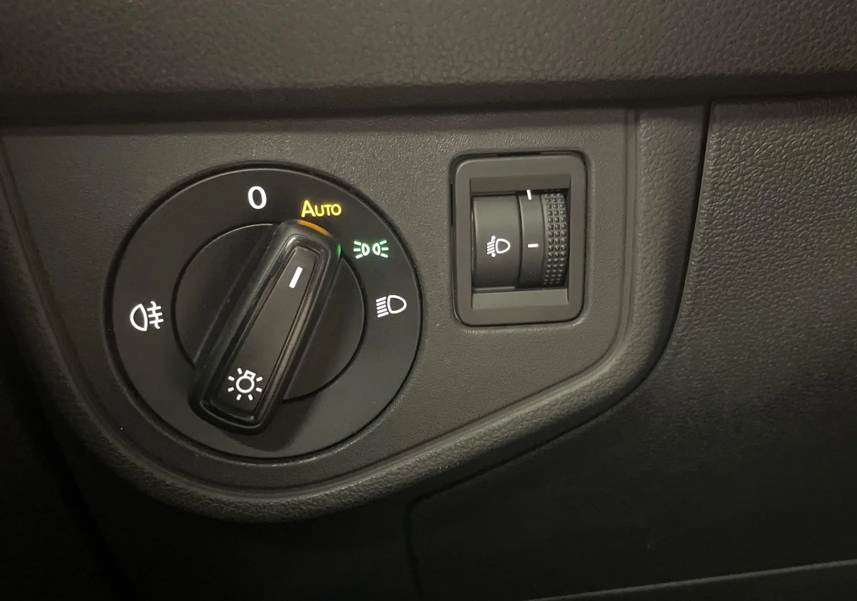 Gros plan sur le bouton de commande des phares du tableau de bord d'une Volkswagen Polo 2023 couleur reflet d'argent.