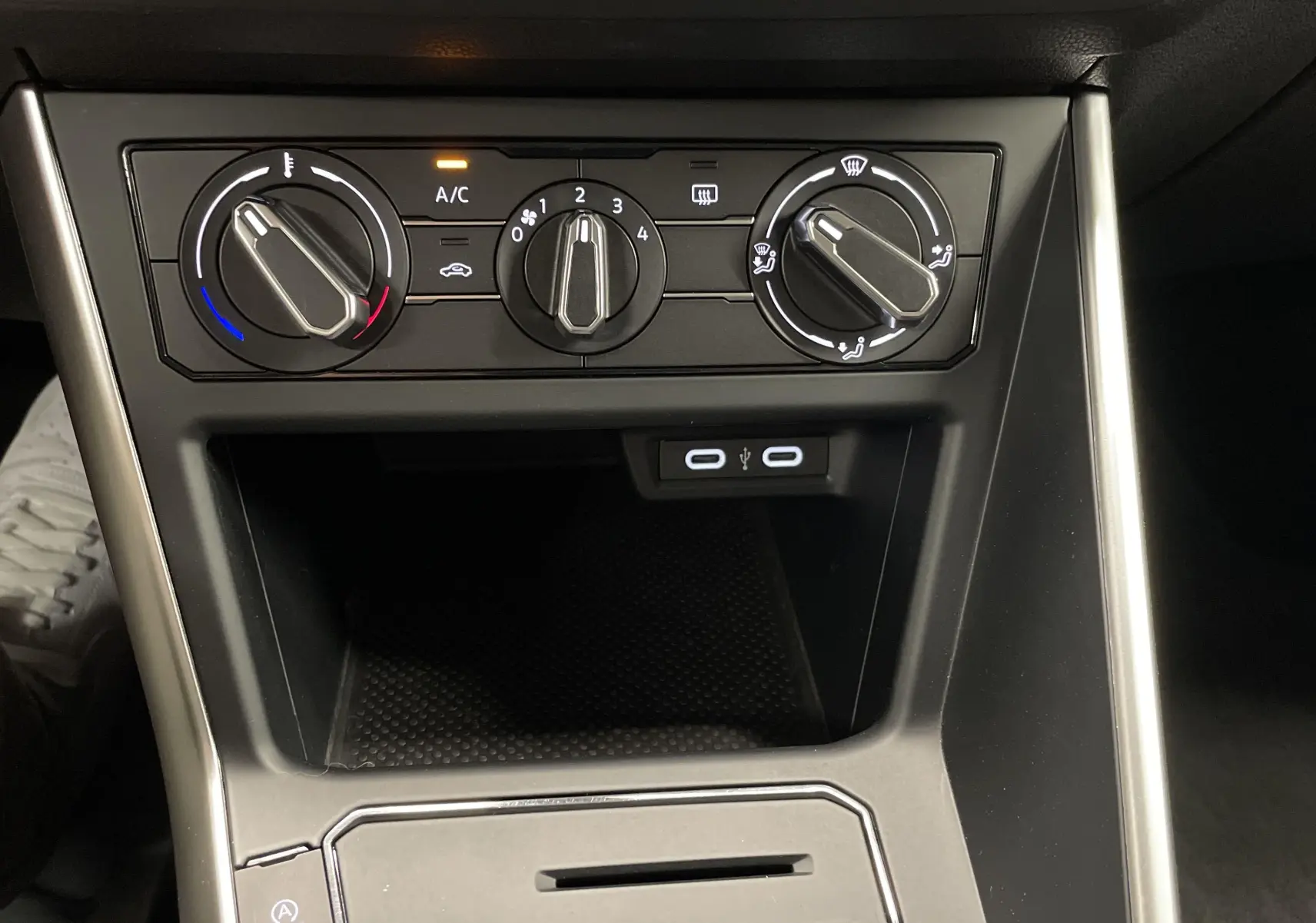 Commandes manuelles de climatisation et deux ports USB visibles sur la console centrale d'une Volkswagen Polo 2023.