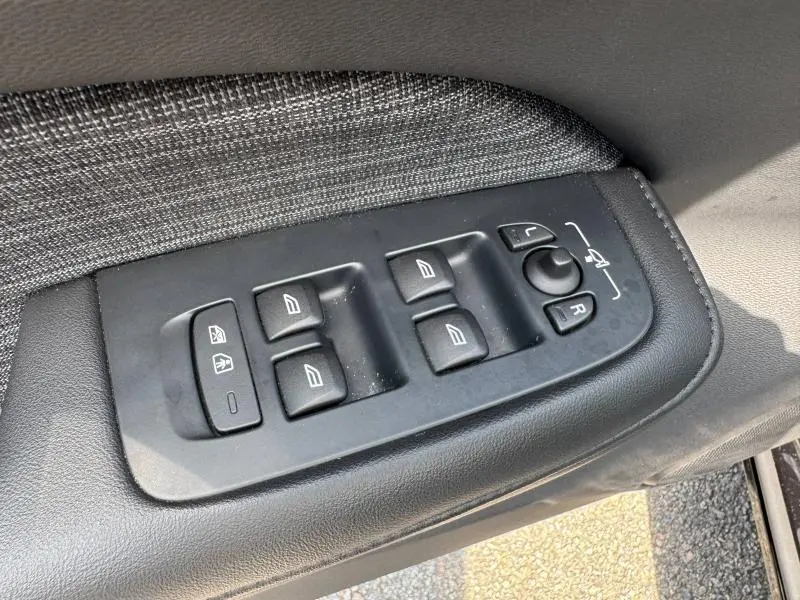 Panneau de commandes des vitres et rétroviseurs côté conducteur d'une Volvo S60 2024, intérieur gris et noir.