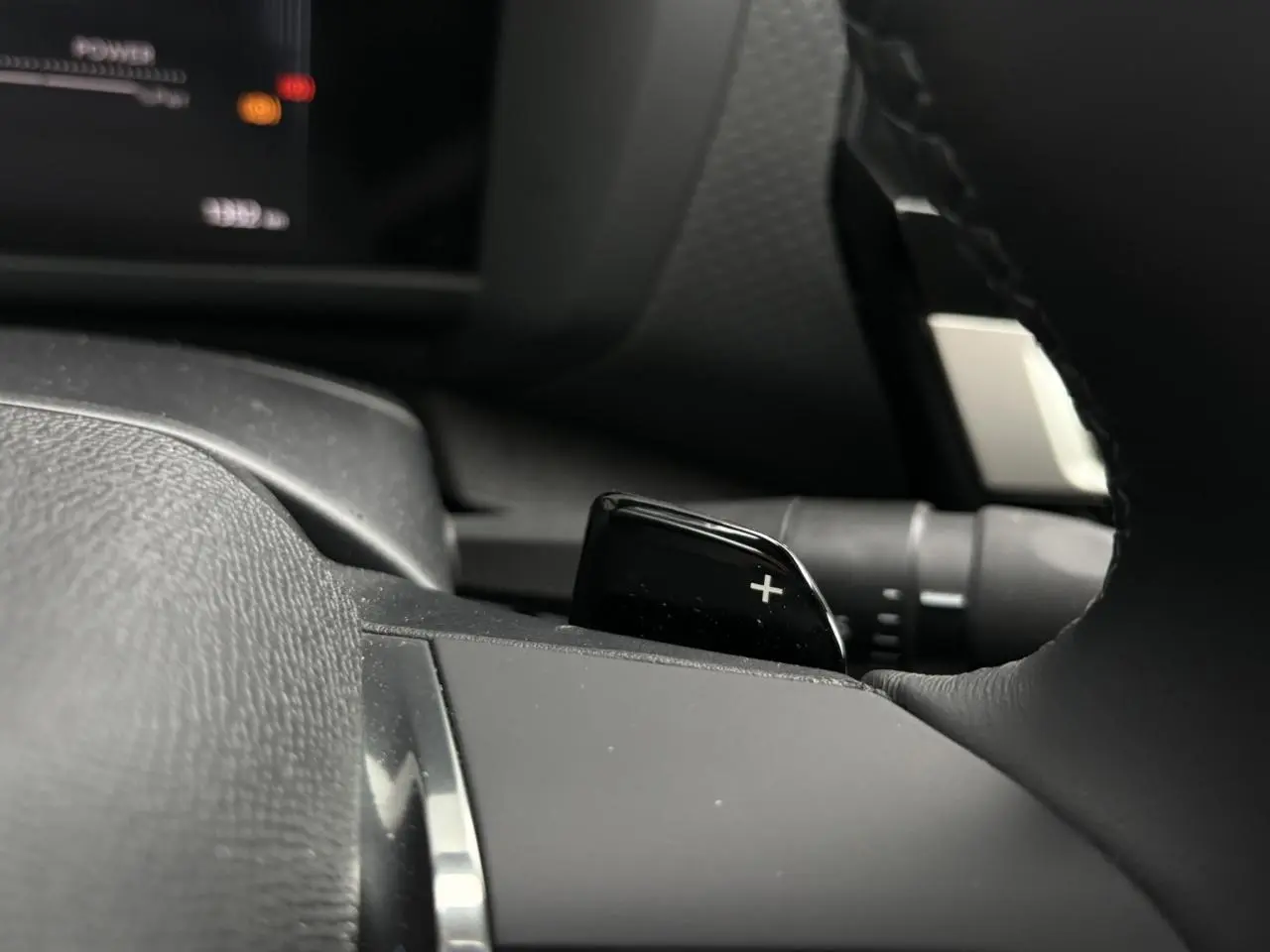 Gros plan sur la palette de changement de rapport droite du volant cuir noir d'une Citroën C4 Hybrid 2025.