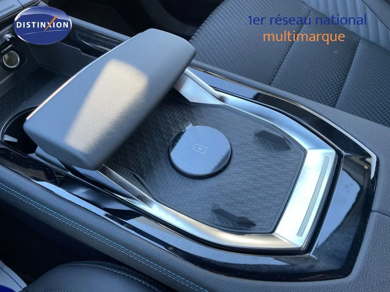 Vue rapprochée de la console centrale noire étoile métal du Renault Austral E-Tech Full Hybrid 200 Esprit Alpine, avec accoudoir et zone de recharge.
